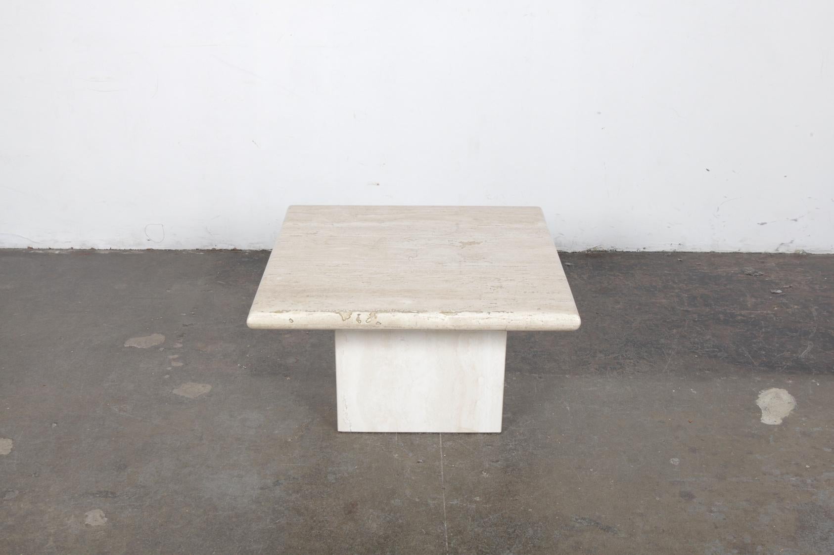Beautiful Italian travertine end table, 1970s, with a square pedestal base and a slight beveled edge to the tabletop. In very nice vintage condition.
