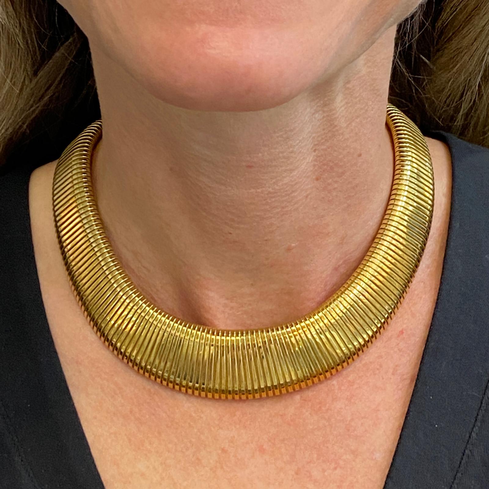Impressive Italian tubogas necklace fashioned in 18 karat yellow gold. The graduated flexible necklace measures .50 -1.0 inches in width, and measures 16 inches in length.