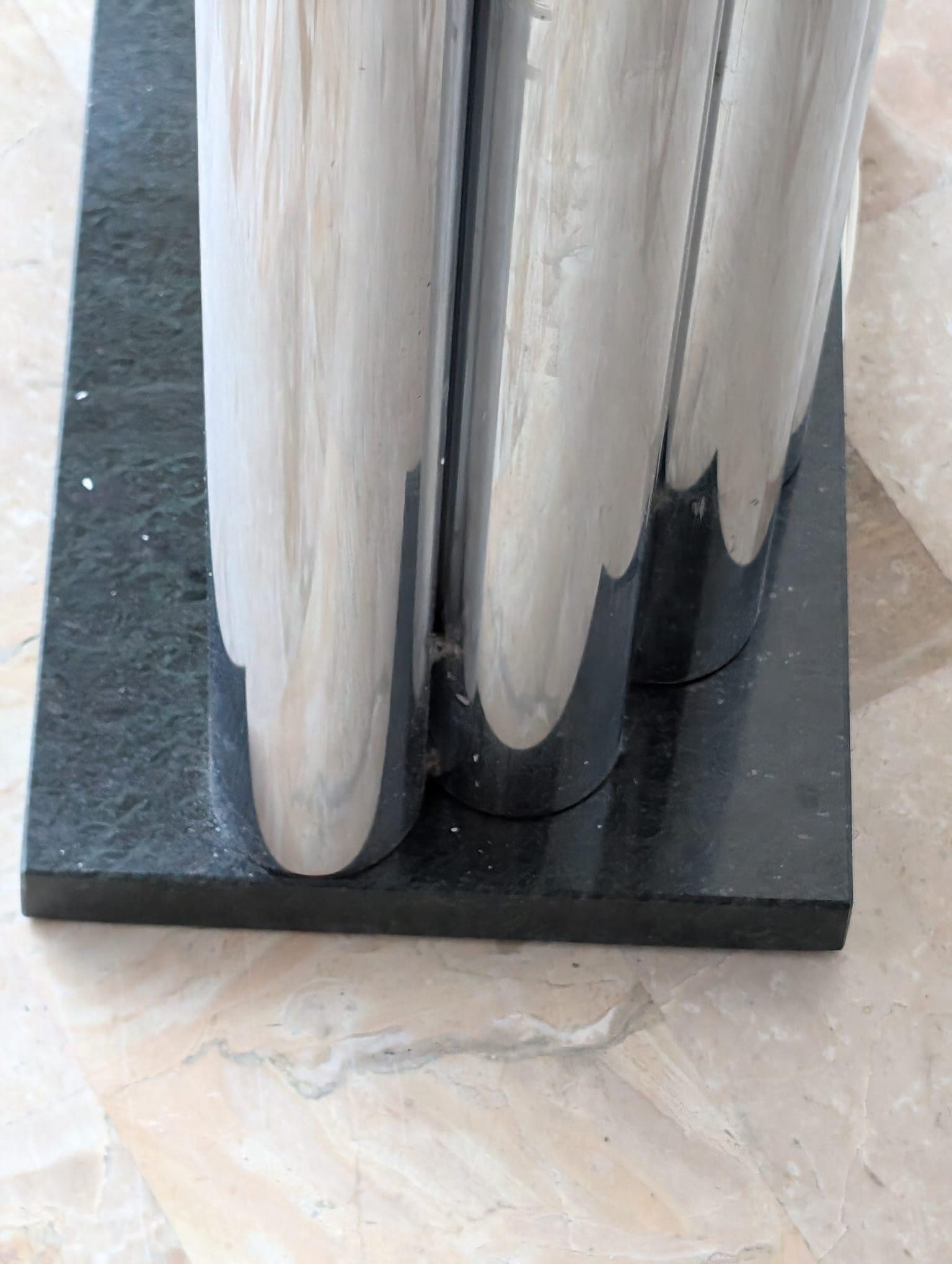 Experimente el encanto de la artesanía italiana con esta impresionante lámpara de pie tubular de los años 70. Diseñada con una fusión ejemplar de acero, cristal acrílico transparente y mármol, esta extraordinaria pieza promete infundir a su espacio