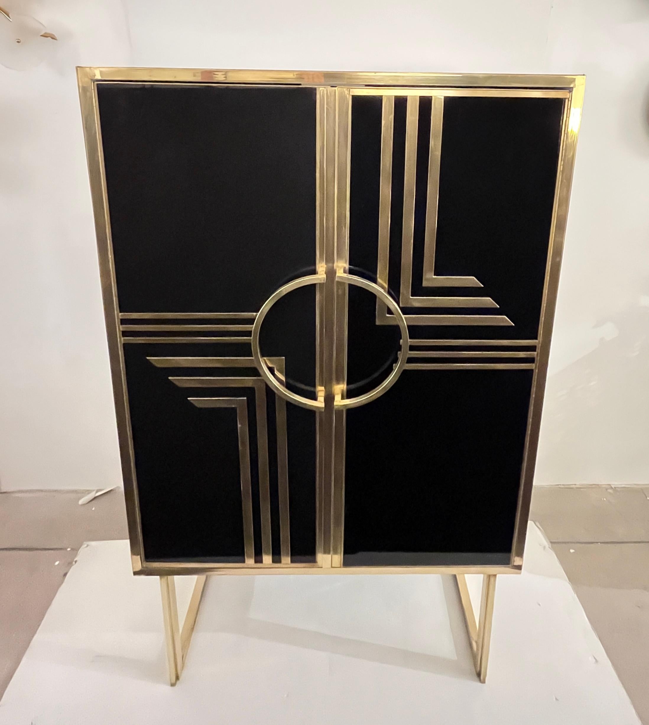 A truly one-of-a-kind, handmade Italian cabinet/dry bar from the late 1970s, entirely hand-crafted in Northern Italy. Its elegant black glass surround is illuminated on all sides by a striking geometric Art Deco gold brass pattern, with high-quality