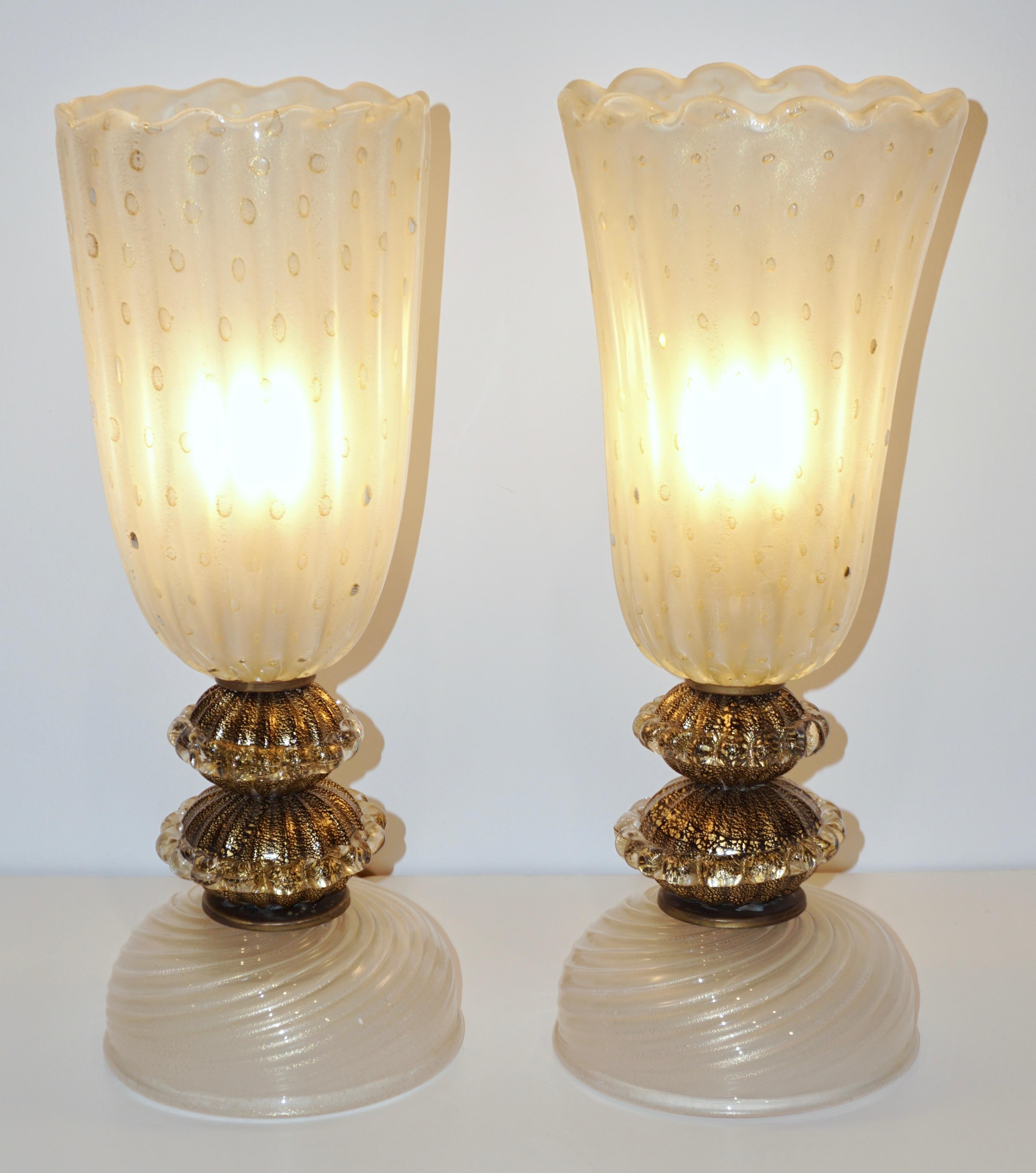 An elegant mid-20th century pair of Venetian table lamps, of organic modern design, blown with maestria by Barovier & Toso: the sophisticated flared ribbed bodies with a scalloped edge in overlaid crystal clear Murano glass are frosted on the inside