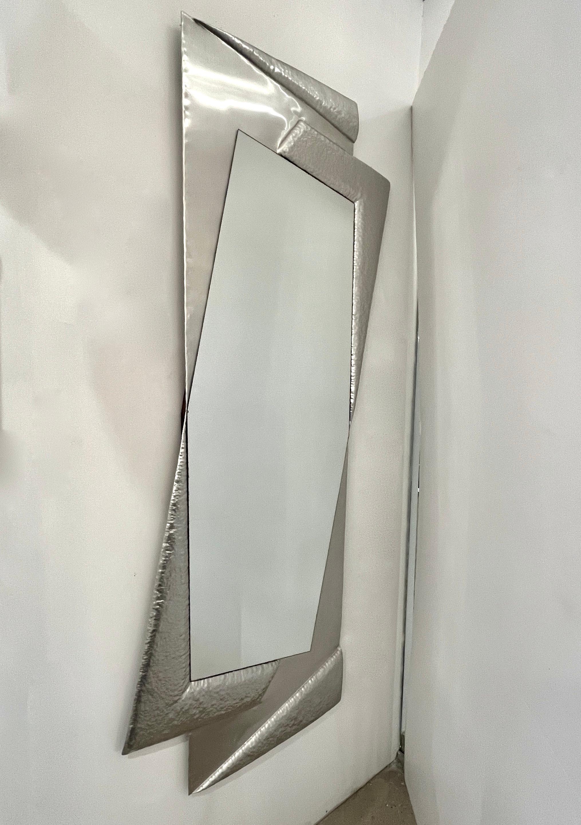 Questo specchio a figura intera in alluminio vintage italiano degli anni '70, unico nel suo genere e interamente realizzato a mano in Italia, presenta un design elegante e scultoreo, con una cornice asimmetrica in alluminio che aggiunge un tocco di