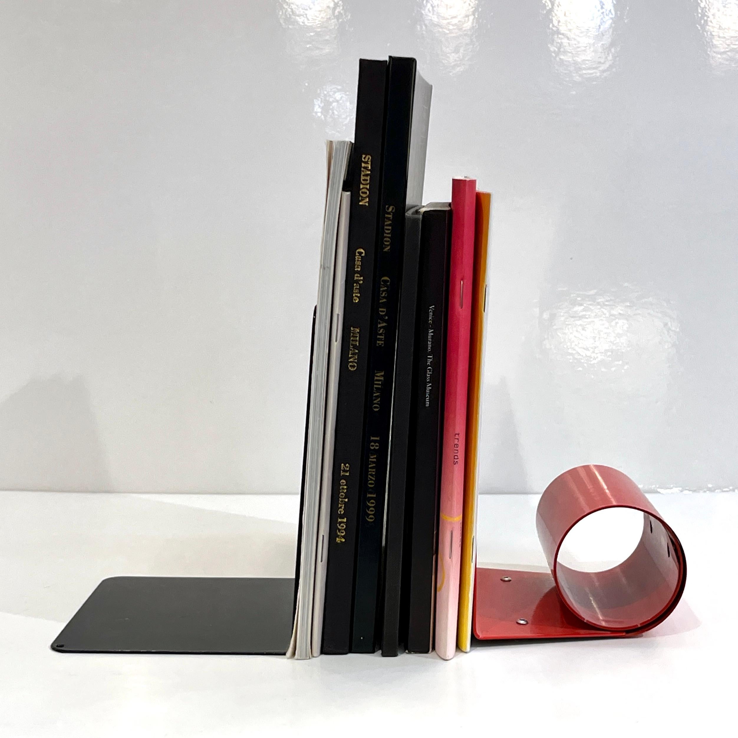 Serre-livres en métal au design moderne et élégant, laqués noir et rouge. Les deux serre-livres sont de style complémentaire mais de forme géométrique différente. Le serre-livres noir présente des détails géométriques percés qui permettent de