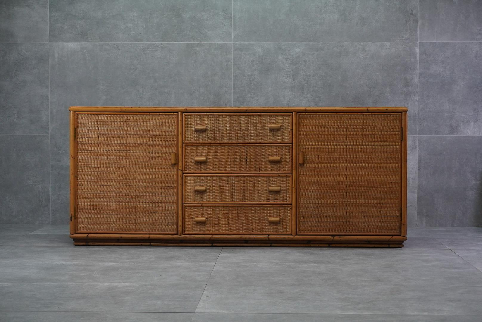 Bellissima credenza italiana in vimini degli anni '70. Offre un ampio spazio di archiviazione con cassetti e armadietti, perfetti per aggiungere texture naturali agli interni.