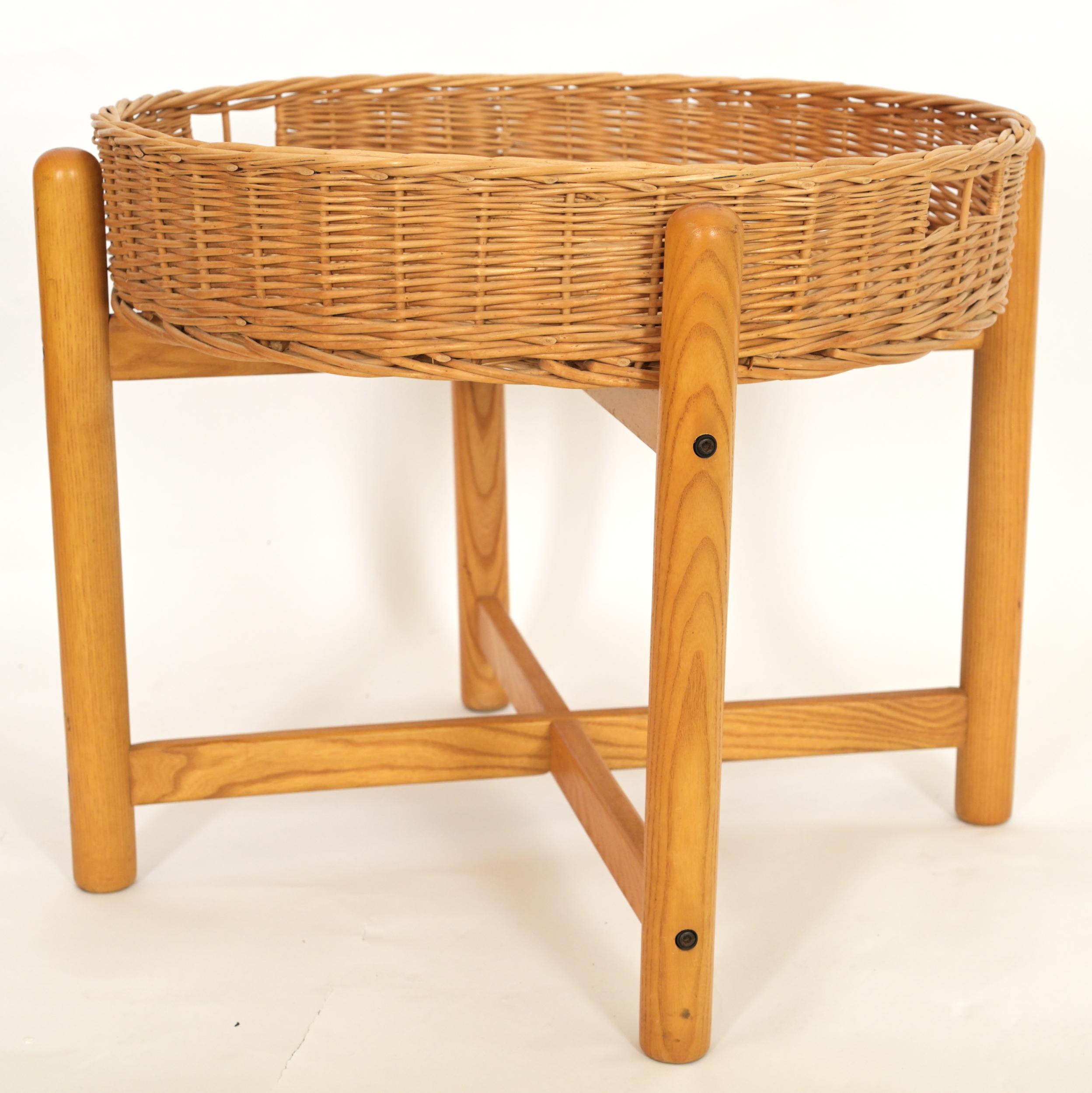 A wicker basket side table having a removable wicker top upon a cross section four leg oak base. Circa 1970.

