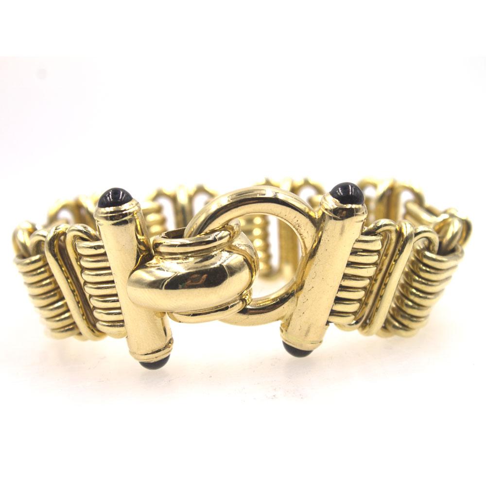 This beautiful Italian estate bracelet is crafted in solid 14 karat yellow gold. This wide link bracelet features a fold over security clasp with 4 cabochon sapphire accents. The bracelet measures 8.5 inches in length and .80-1.25 inches in width. 