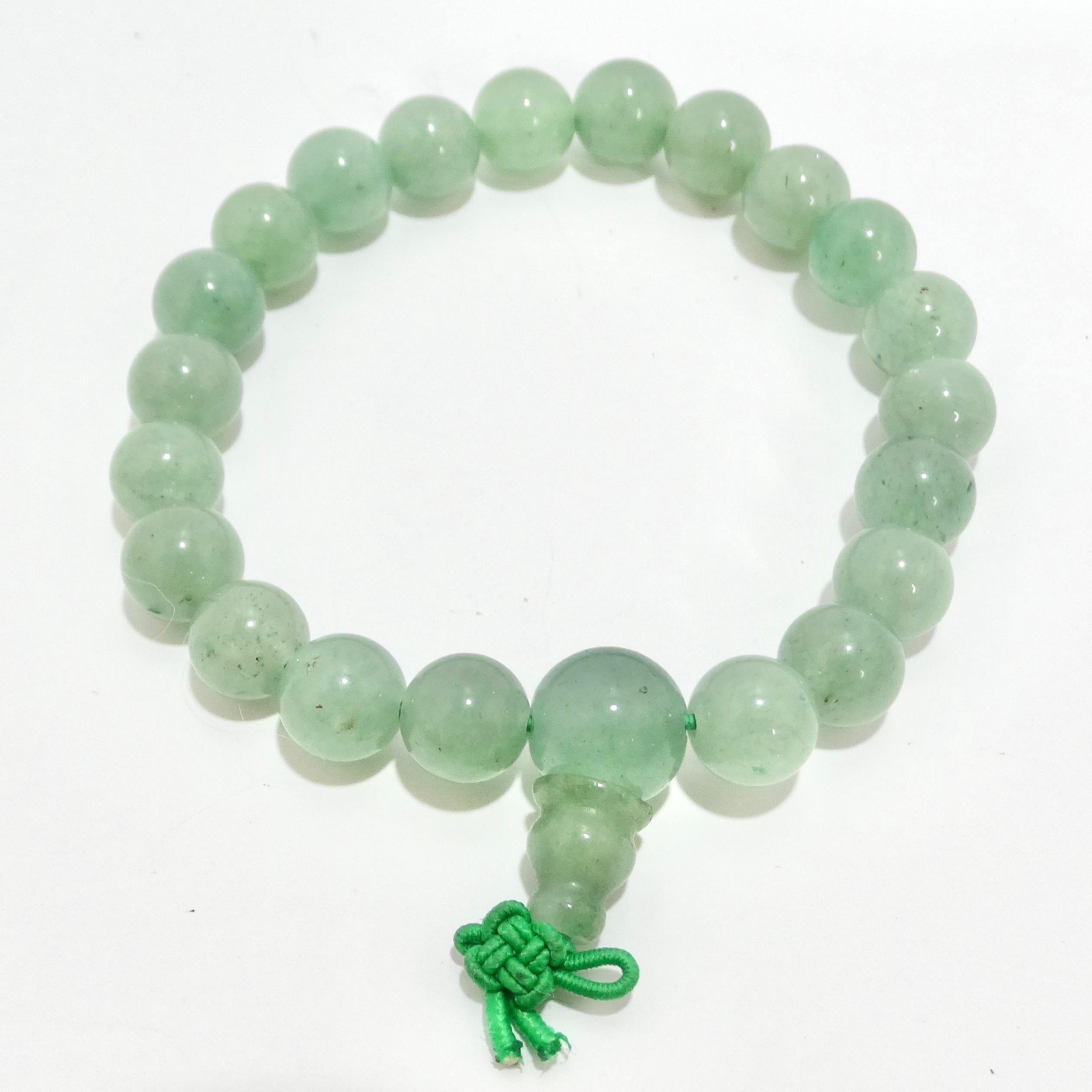 Adorn your wrist with the elegance of the 1970s Jade Jadeite Beaded Bracelet, a timeless piece that radiates natural beauty and sophistication. This Chinese jade malà bracelet showcases stunning jade ball-shaped beads, strung on a stretchy green