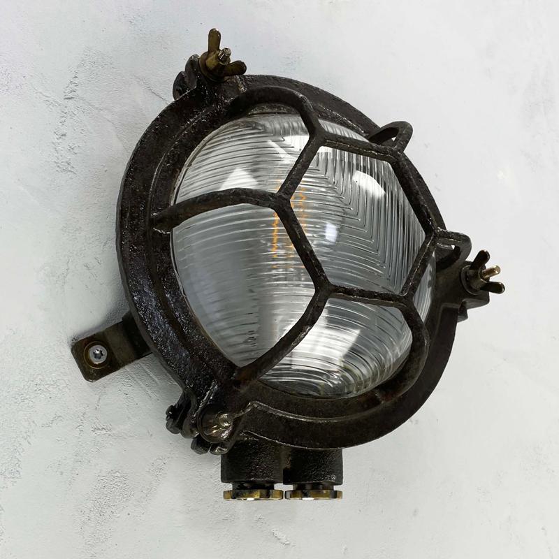 Vintage industrial cast iron circular bulkhead wall lighting with a hexagonal target cage and chevron reeded glass. Perfect robust and rustic light fixtures.

Reclaimed fixtures originally used on cargo ships and supertankers to illuminate