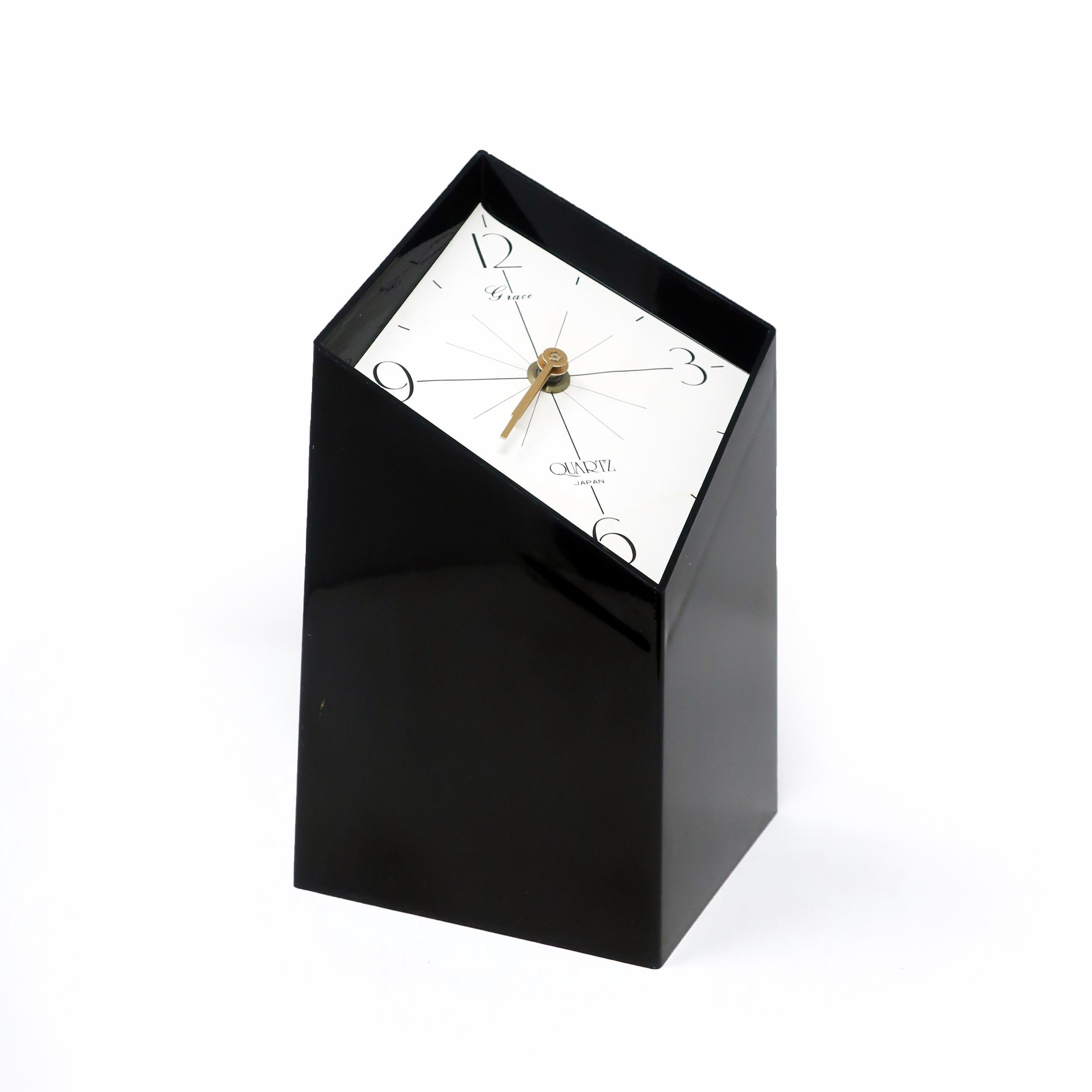 An amazing vintage black desk or table clock with a black plastic body and a white face made by Grace, a Japanese company. Diamond shaped with a diagonal face, giving it a fantastic three dimensionality. The clock's movement is inset inside of the