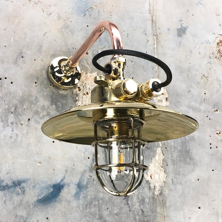 An industrial brass explosion proof wall light fixture with a bespoke brass and copper cantilever arm.

The lamp was originally made in Japan which was reclaimed from decommissioned cargo ships made during the 1970s. Then

 This fixture has been