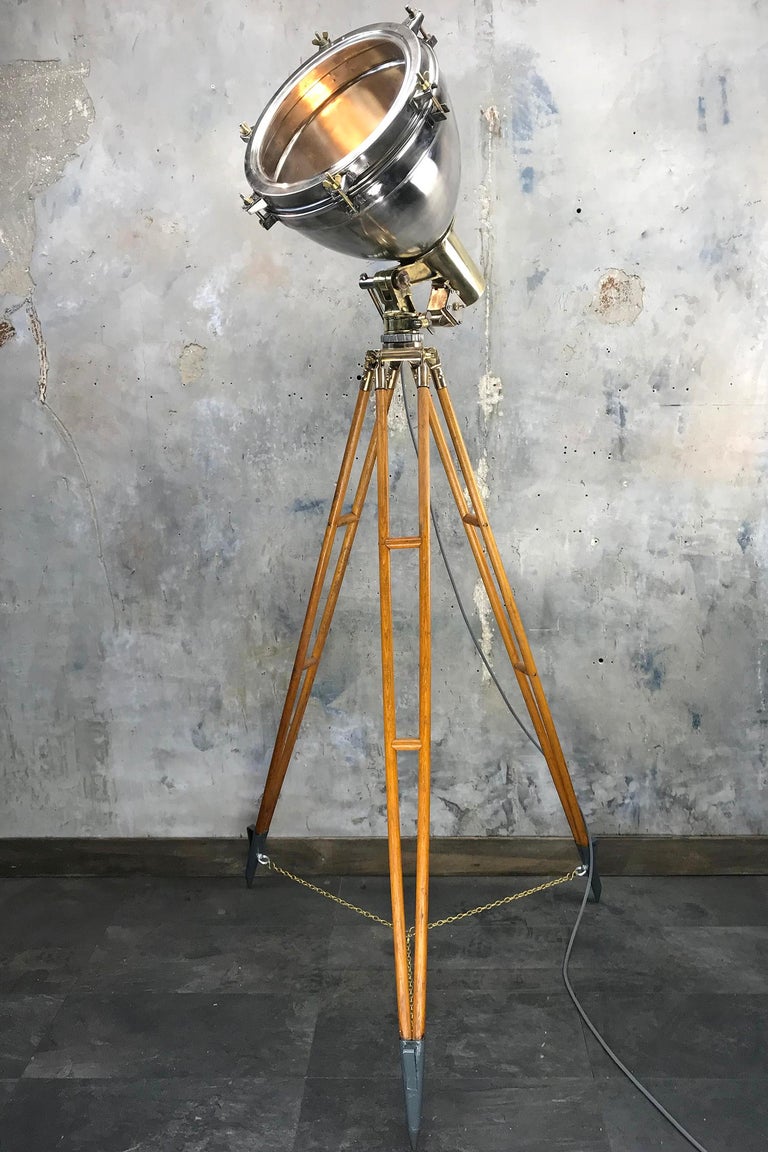 A fine example of an industrial style Loomlight tripod floor lamp, comprised of a brass and stainless steel searchlight with timber and bronze tall tripod.
The lamp is a very substantial fixture with all wiring replaced with our in house wiring