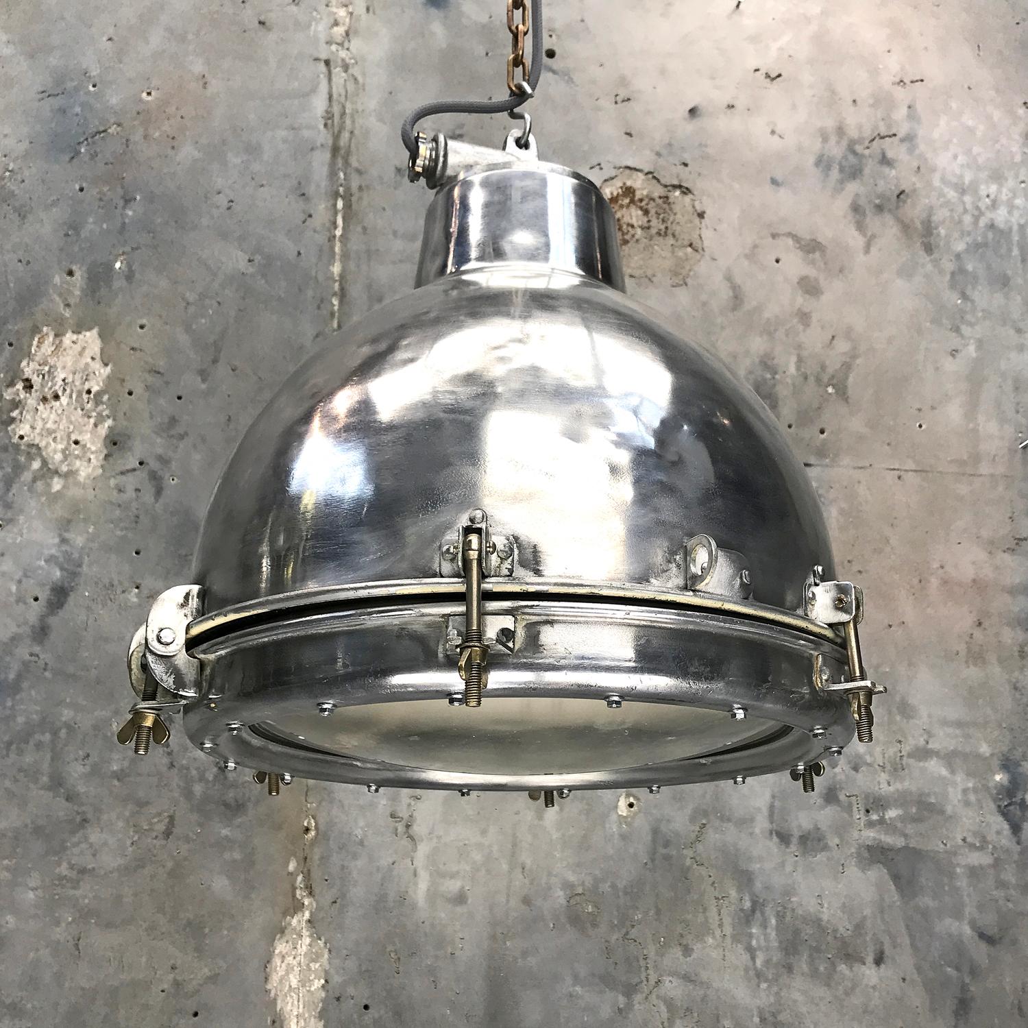 Polished aluminium dome pendant with toughened convex glass lens.

Originally used on super tankers and cargo ships built during the 1970s and were manufactured to IP65 standards.

The heavy convex glass opens the beam for a wider light