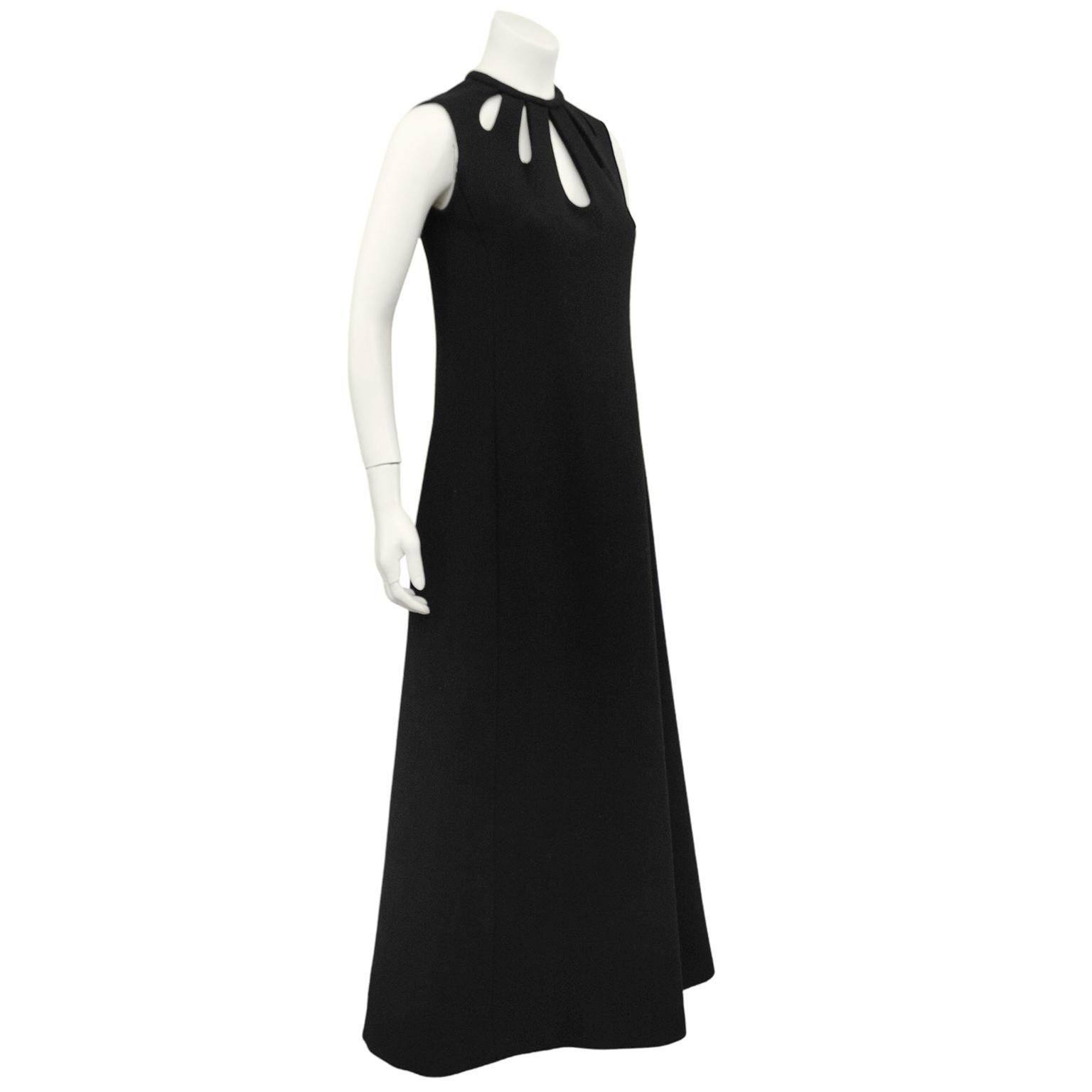 Stunning and graphic black wool Scherrer gown from the early 1970s. Sleeveless with tube piped collar and cascading teardrop shaped cutouts on front and back. Gorgeous minimal a line shape hits the floor. Zipper up centre back. Excellent vintage