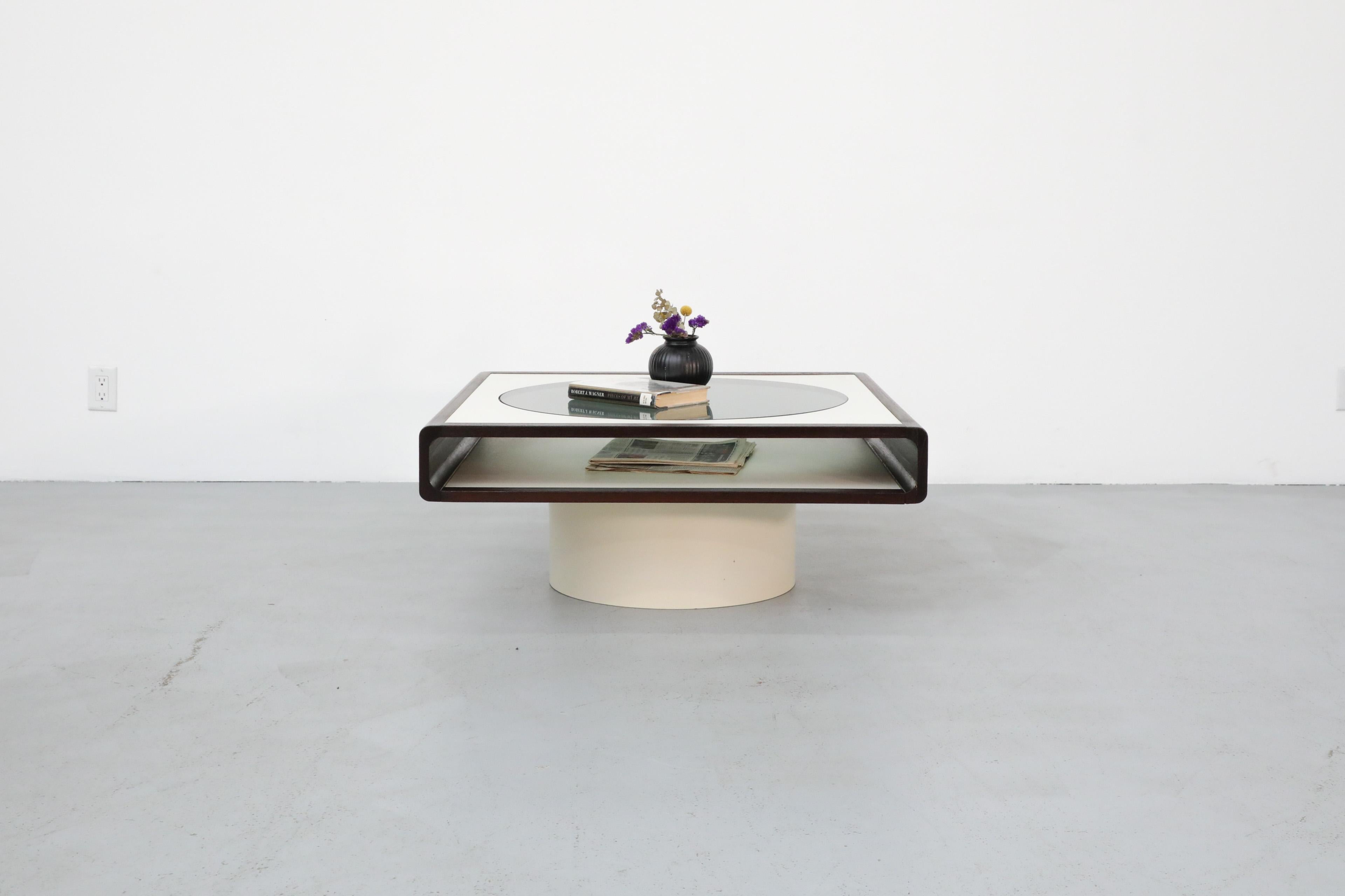 Beautiful coffee table with a space age aesthetic that stands out for its distinct geometric shapes and smoked glass inset that creates a 