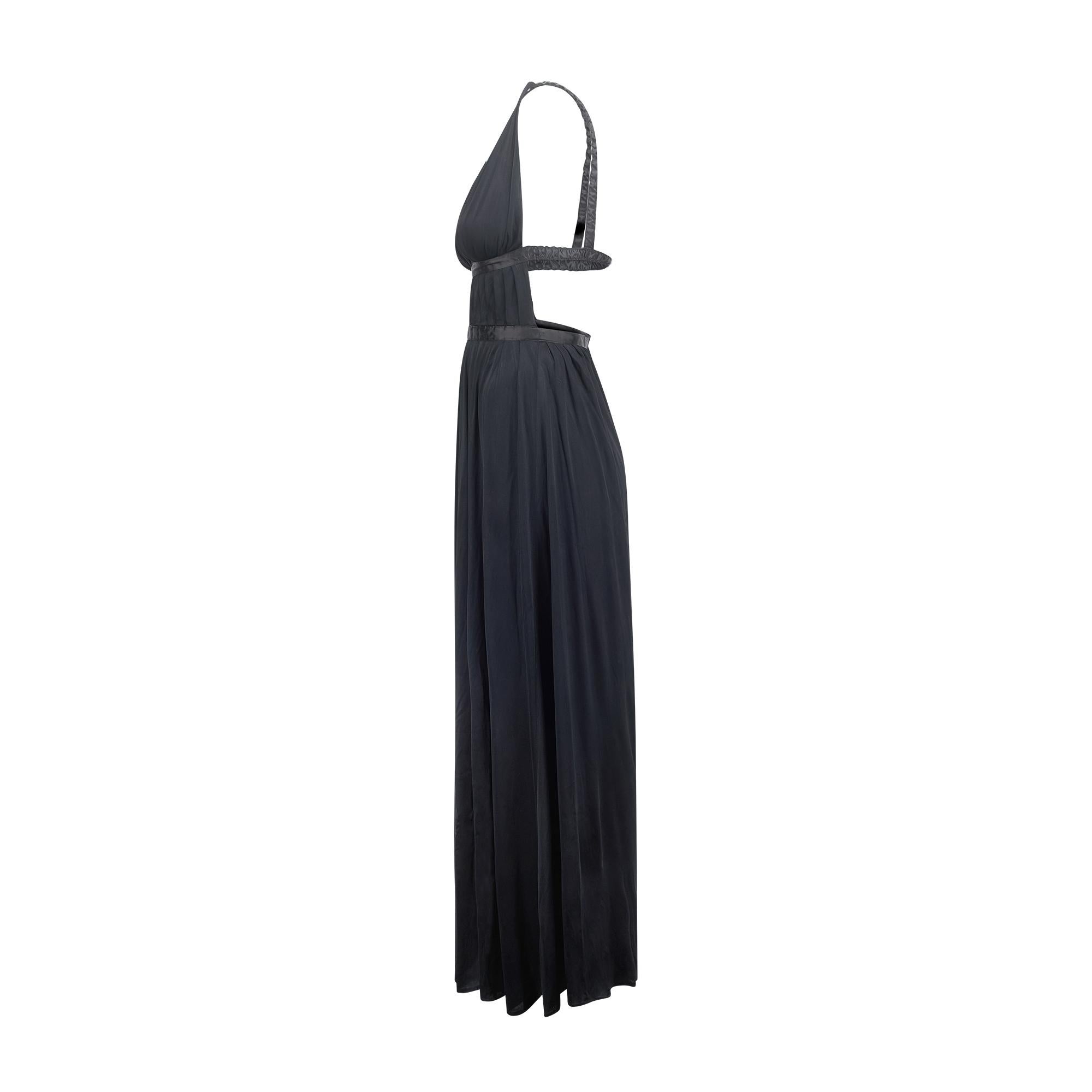 Un mono negro muy llamativo de Jean Varon que data de principios de los años 70, pero tiene un diseño sorprendentemente contemporáneo. Está confeccionado en un jersey negro fluido y brillante con un toque de elasticidad y cae hasta el tobillo. De