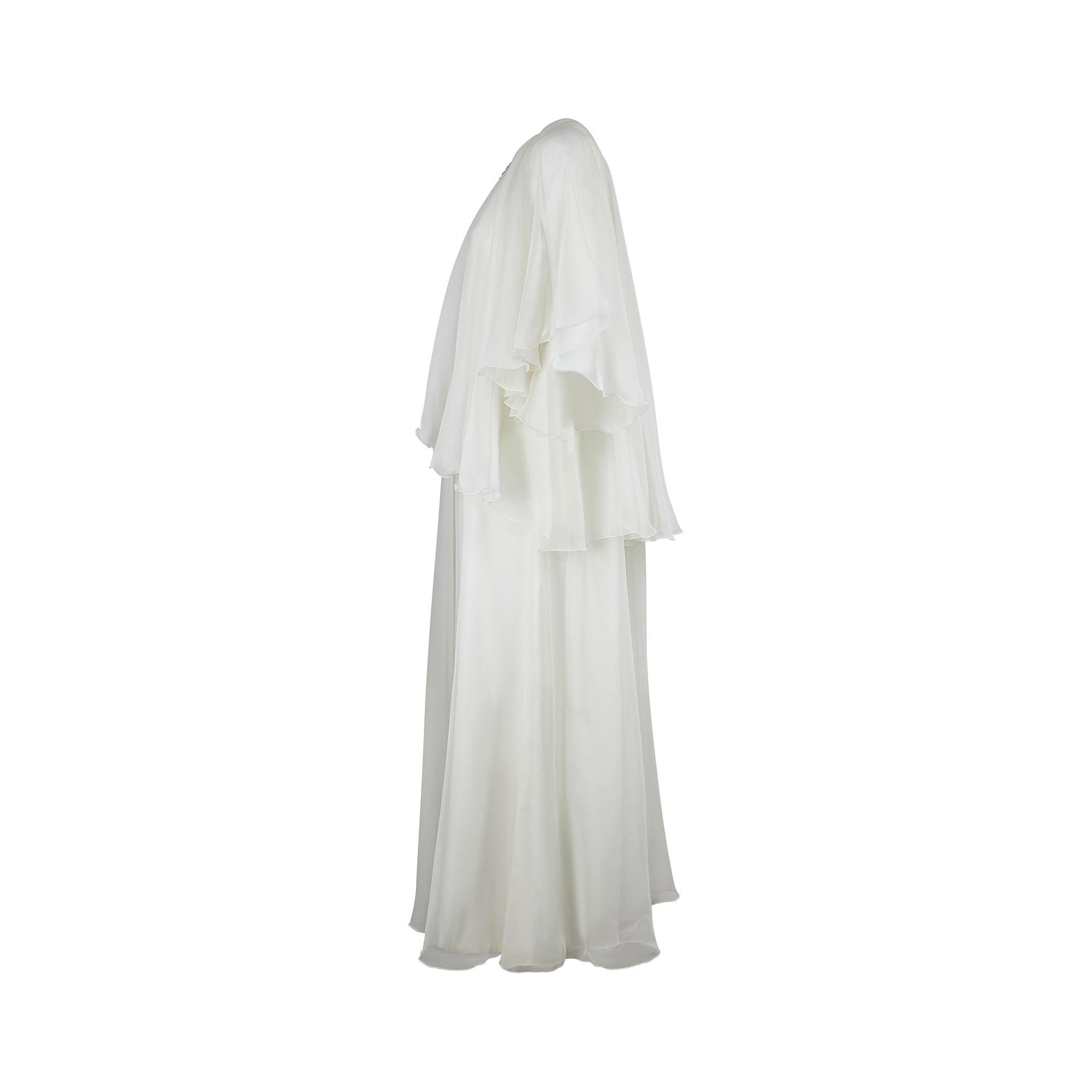 This ethereal wedding dress dates from the mid 1970s, with its tiered construction, caped shoulders and layers of frothy pale cream georgette. The skirt is formed from a cream acetate lining topped with a sheer layer of polyester georgette. An