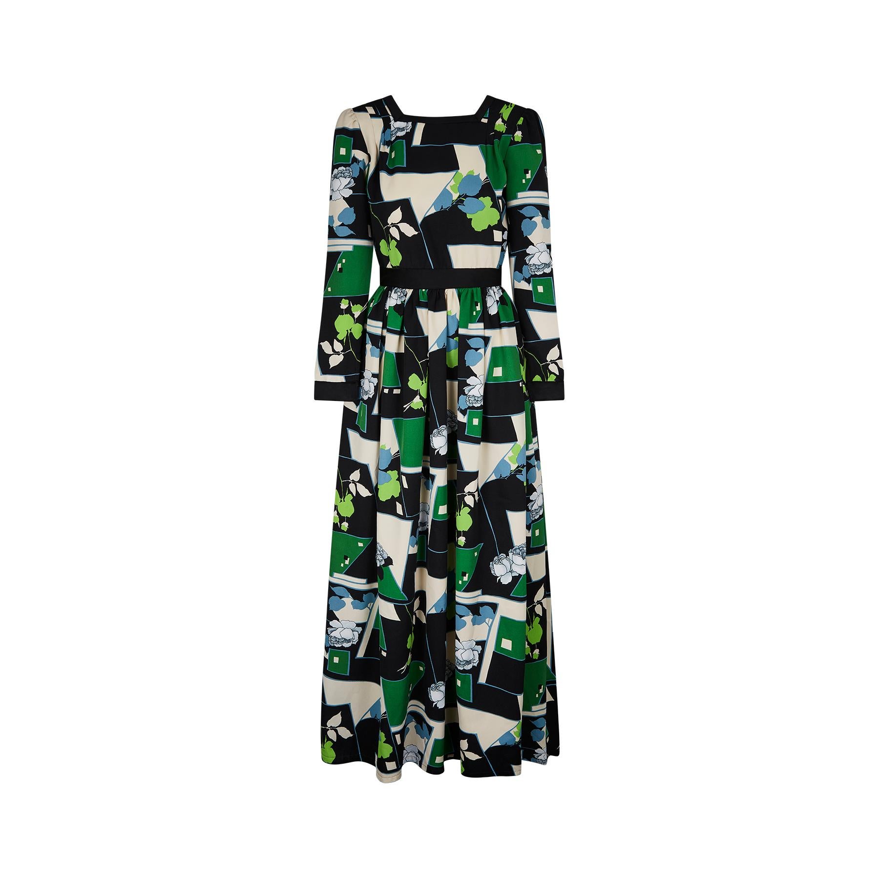 This late 1960s to early 1970s rose print maxi dress is by the renowned British designer John Bates who traded under the Jean Varon label. The striking print combines colours of navy blue, sky blue, green, acid green and white. It has a square neck,