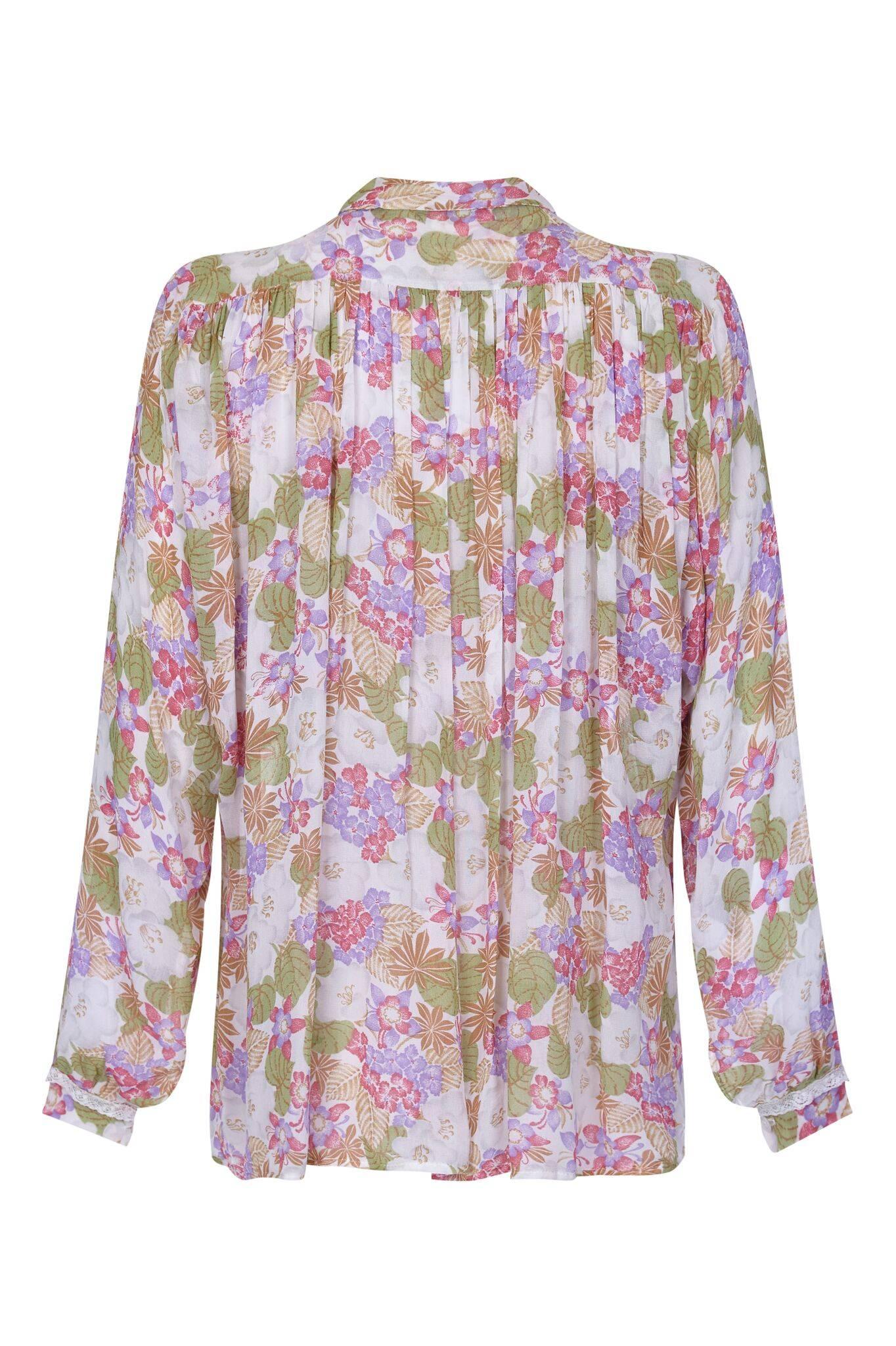 This pretty 1970s Jeff Banks chiffon blouse is gorgeously feminine with some lovely details. The light chiffon has a floral pattern of pastel tones in ivory, soft green, ochre, rose pink and lilac. The generous cut of the fabric and batwing sleeves