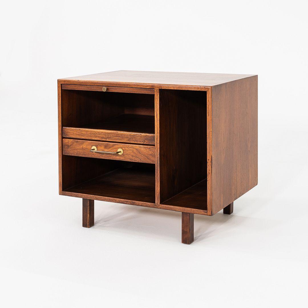 This is a Walnut Nightstand, originally designed by Jens Risom for Jens Risom Designs. This particular example was handcrafted in the United States and dates back to the 1970s. The nightstand is comprised of a walnut frame and features one small