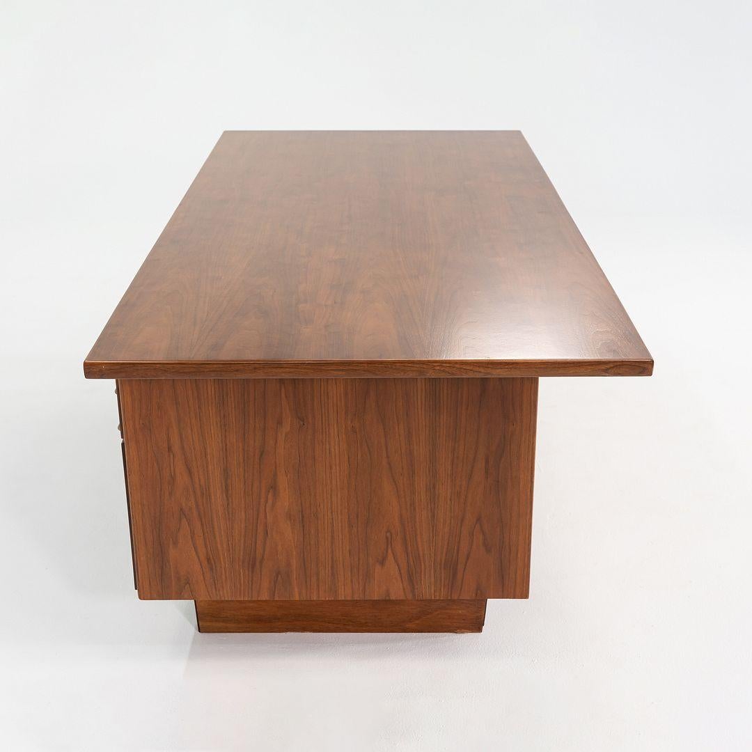Dies ist ein Chefschreibtisch aus Nussbaum, entworfen von Jens Risom in den 1960er Jahren. Dieses Exemplar wurde von Risom Design Inc. hergestellt und stammt aus den 1970er Jahren. Der Schreibtisch ist mit fünf Schubladen ausgestattet, die reichlich
