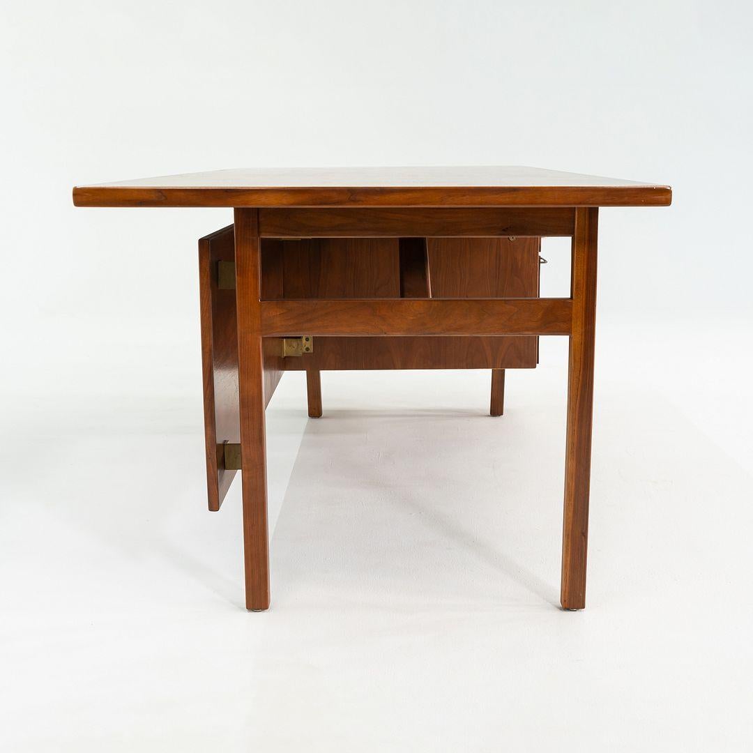 This is an Executive Desk in Walnut, designed by Jens Risom in the 1960s. Produced by Risom Design Inc. this example dates to the 1970s. It features several drawers which provide ample storage, and offers a kneehole space for your desk chair. It