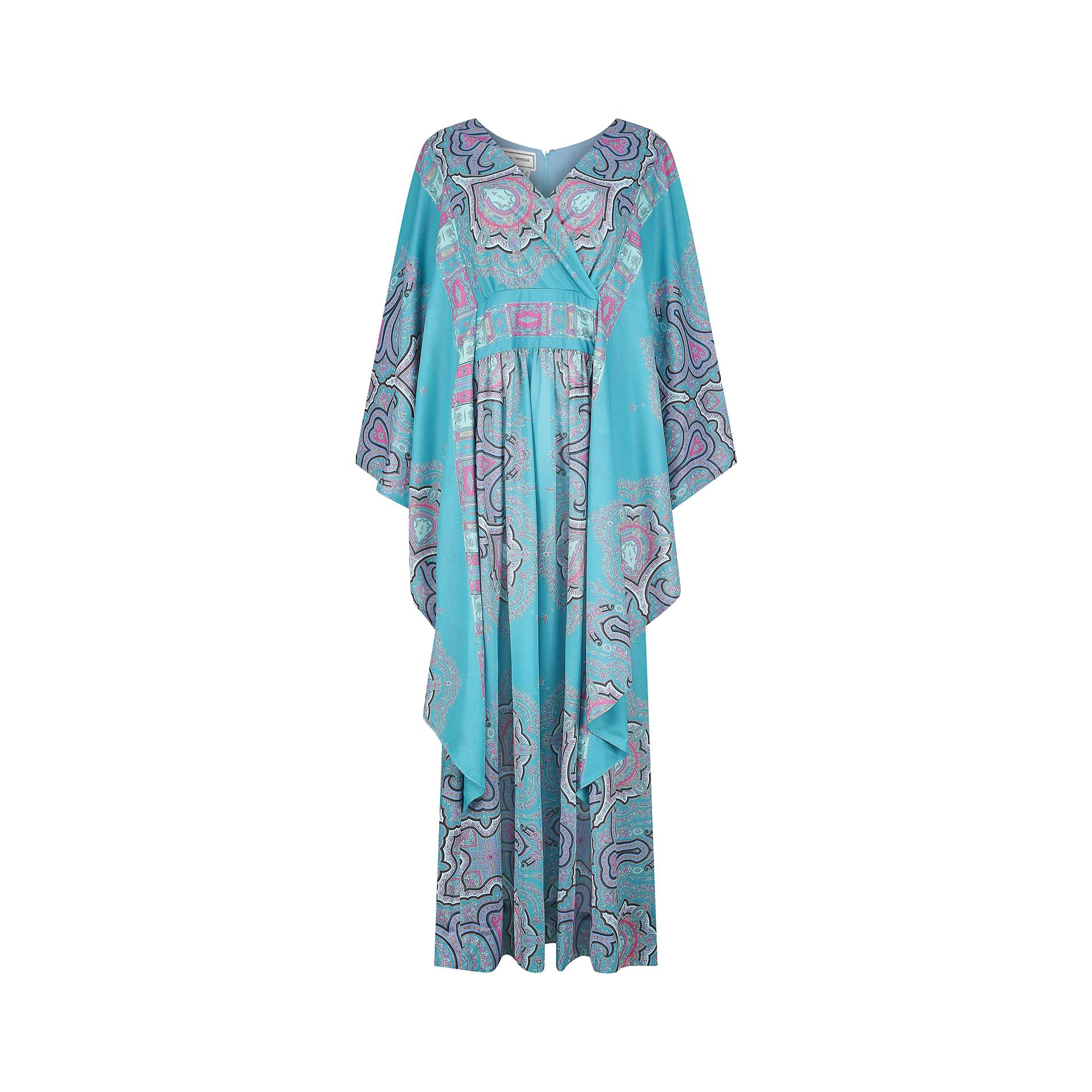 This 1970s John Neville turquoise paisley dress is the perfect pack away dress and made from a high quality polyester yarn with a lined bodice. It has a V-neck crossover front, wide empire line waistband and flowing, kaftan style sleeves. The front