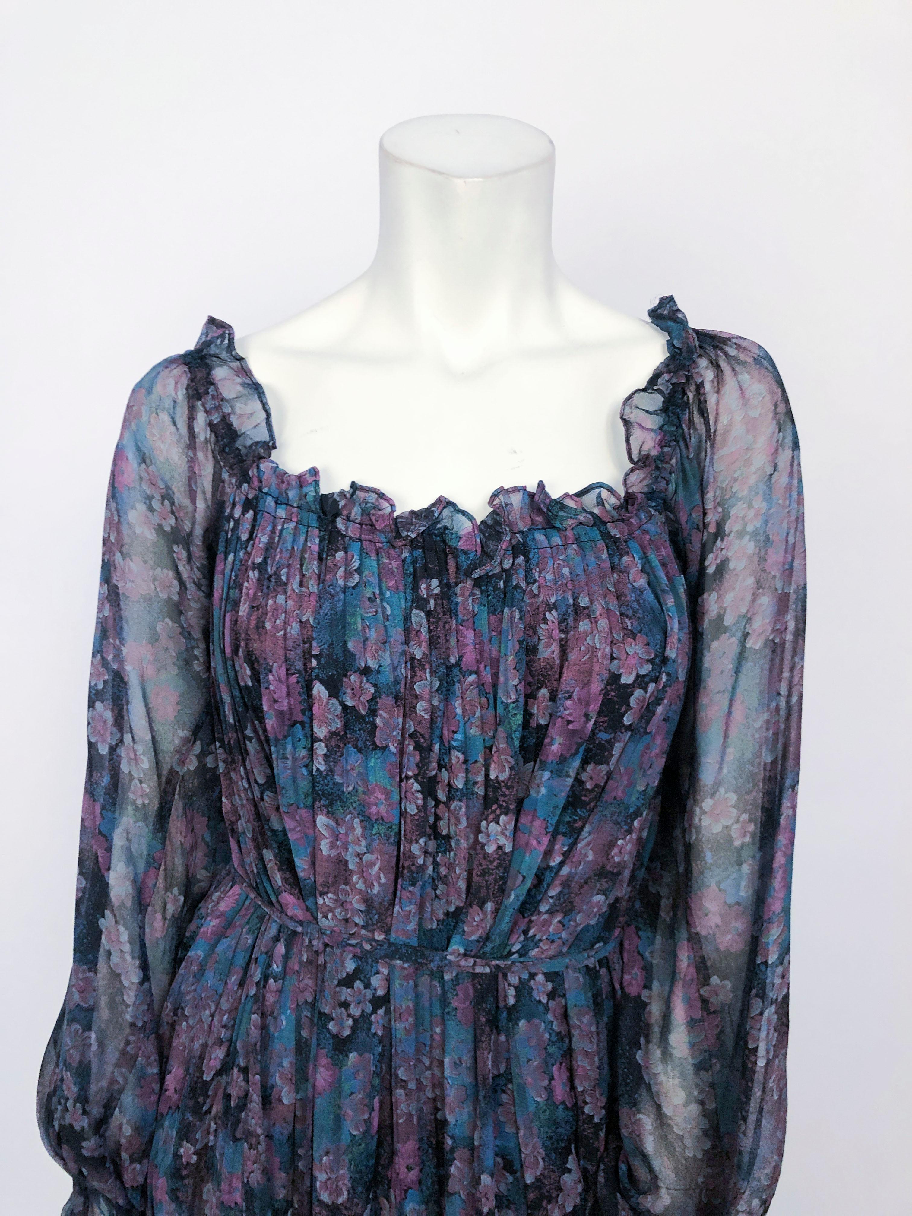 Printed bohemian dress featuring a floral print in violets and blues. This dress is flowy, fully lined, and has peasant sleeves finished with an elasticated ruffled cuff. The neckline is extremely elasticated meaning that it could be styled over the
