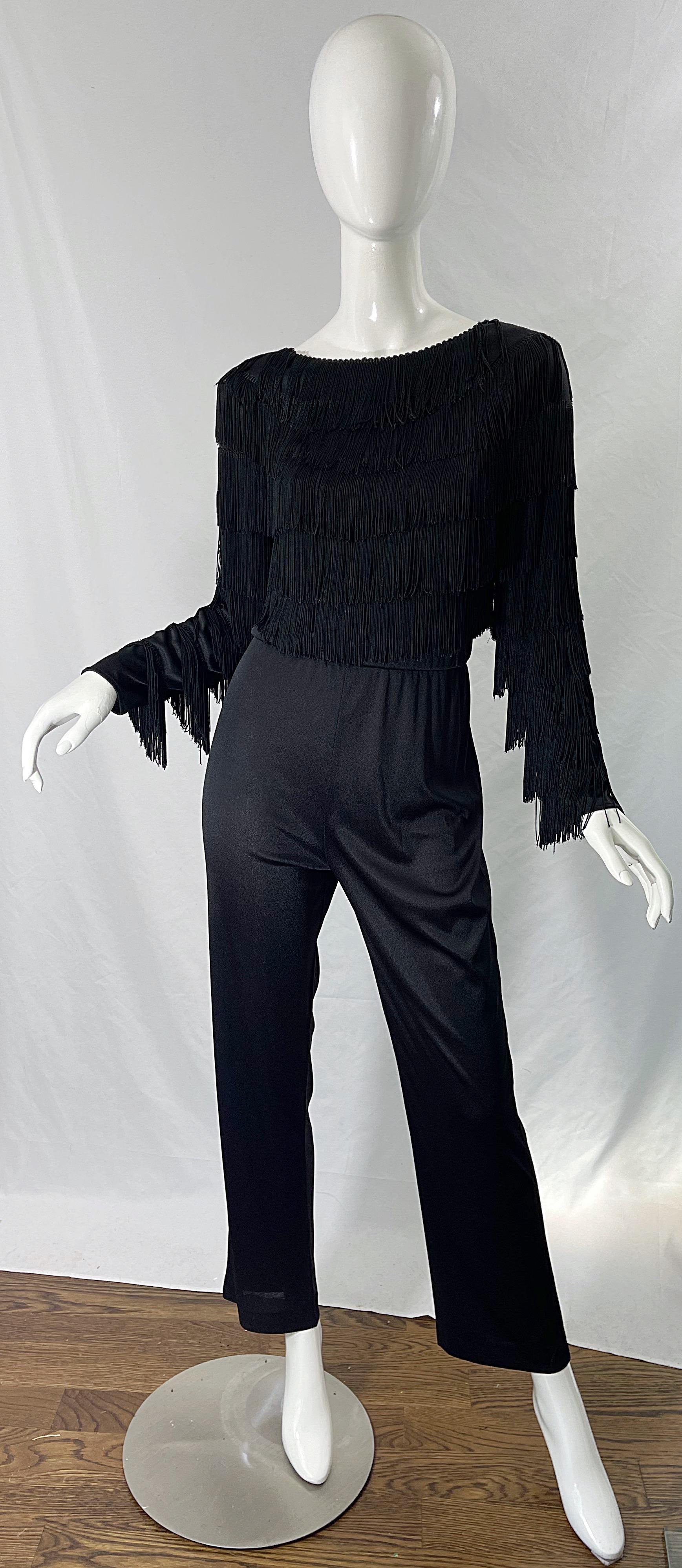 Amazing late 1970s JOY STEVENS jet black fringe jersey jumpsuit ! Features a tailored bodice with layers of fringe on the front, back and sleeves. Hidden zipper up the back with hook-and-eye closure. The perfect alternative to a dress! Great anytime