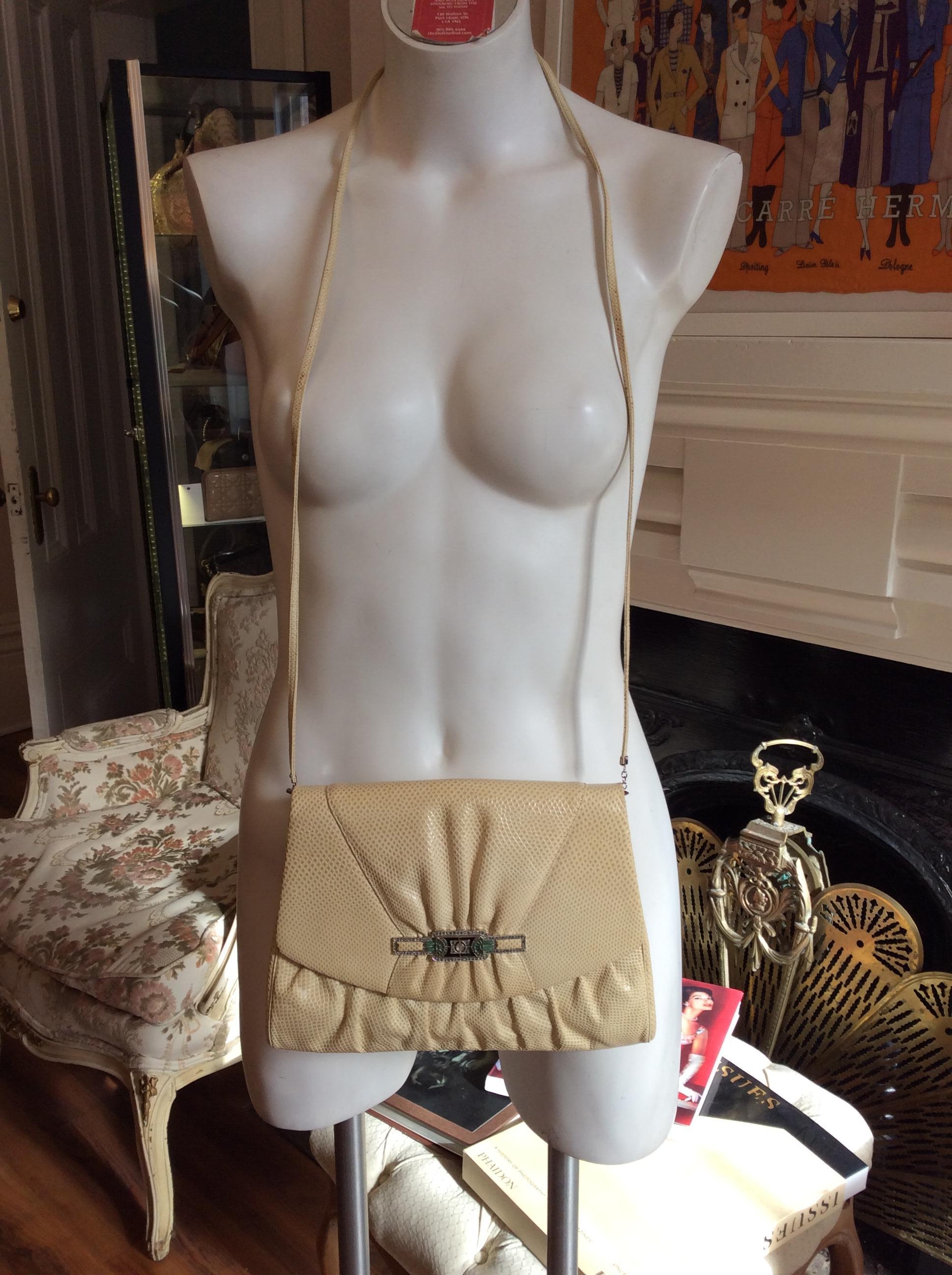 This bag can be worn crossbody or detach the strap and use it as a clutch. There is a slit pocket in the back and the lining features both a zipped and a slit pocket.

The front is decorated with an 