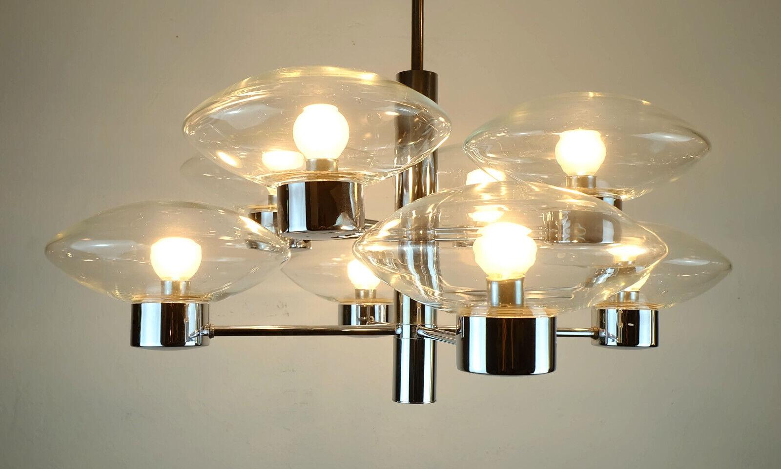 Outstanding 1970s pendant light manufactured by Kaiser-Leuchten. Chrome plated metal, 8 clear glass shades in ufo-shape. Holds E14 bulbs. 
 
Length approx. 37.79