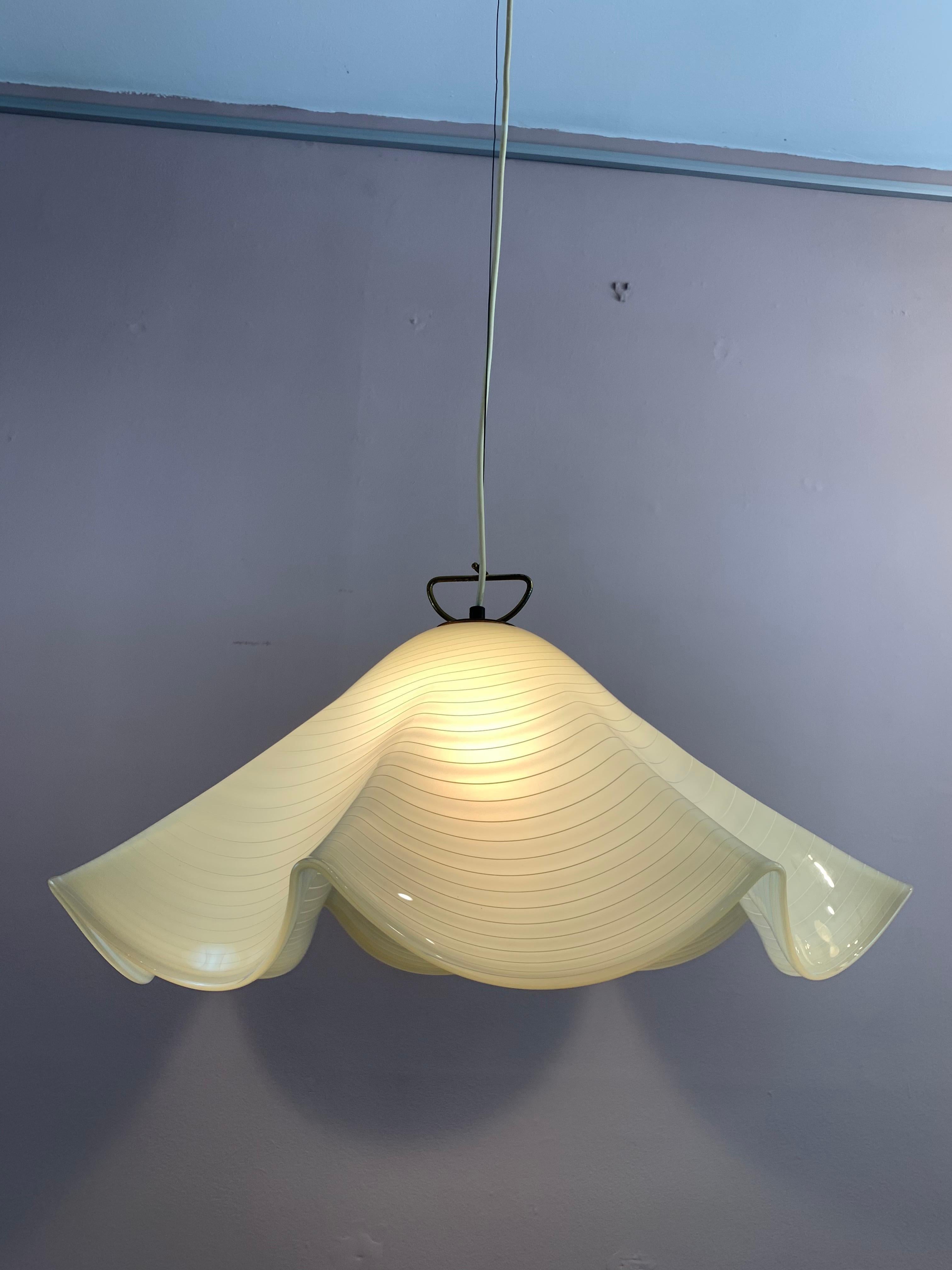 Murano hand blown 'handkerchief' glass hanging ceiling light. The light was manufactured by Kalmar Franken KG in Austria during the 1960s-1970s. The light ochre colored glass has white horizontal stripes around the outside with a brass handle with