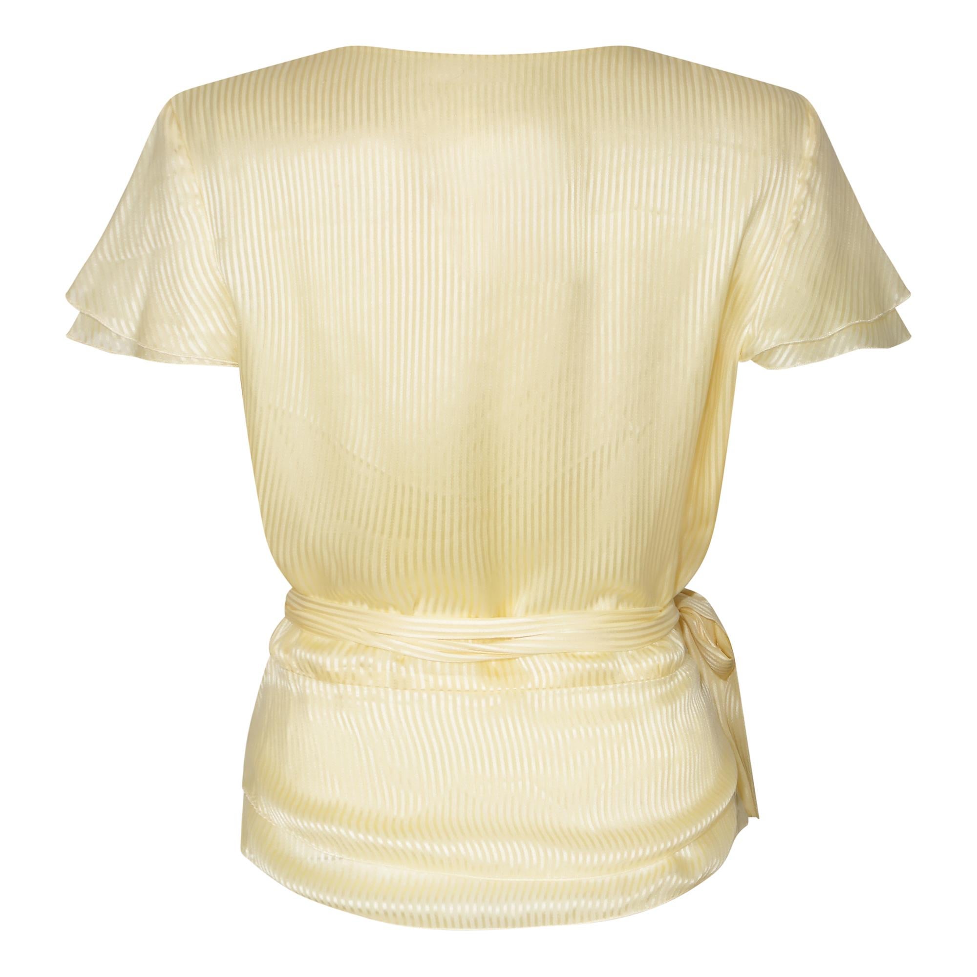 This pale yellow silk wrap around blouse is classic and timeless; so much so that it is difficult to date.  We like to think this was designed by Karl Lagerfeld who had a long association with the now iconic fashion house from the late 1960s through