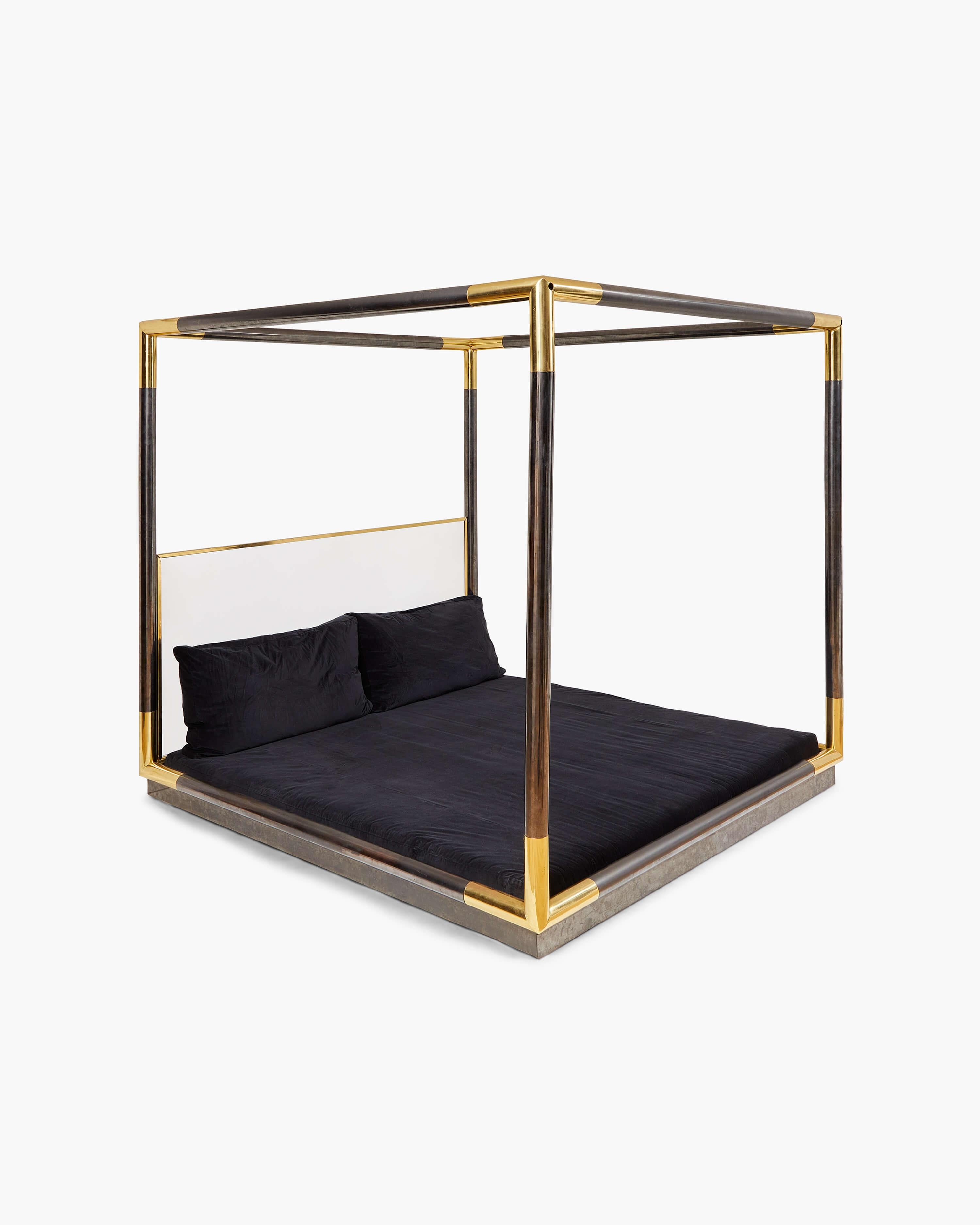Extremely rare, Karl Springer’s sleek and inviting canopy bed captures his unparalleled eye for fusing unusual materials into the ultimate statement piece. 

The frame, constructed from exquisitely finished gunmetal with brass corners, and lucite