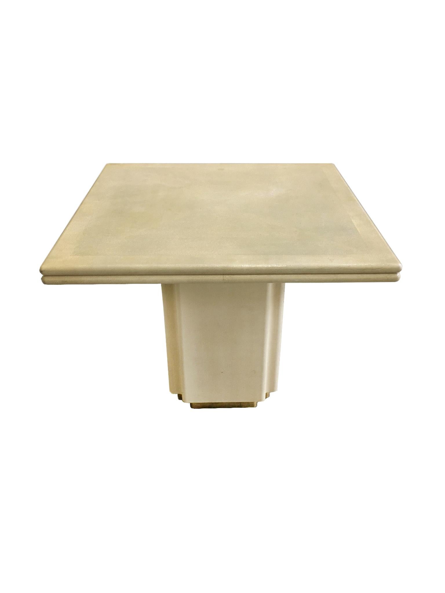 A game table in the style of Karl Springer, made in the 1970s. In the spirit of Springer's luxe designs, the table draws inspiration from Art Deco, combining simplicity and lavishness. The table is wrapped in a pale cream yellow snakeskin.