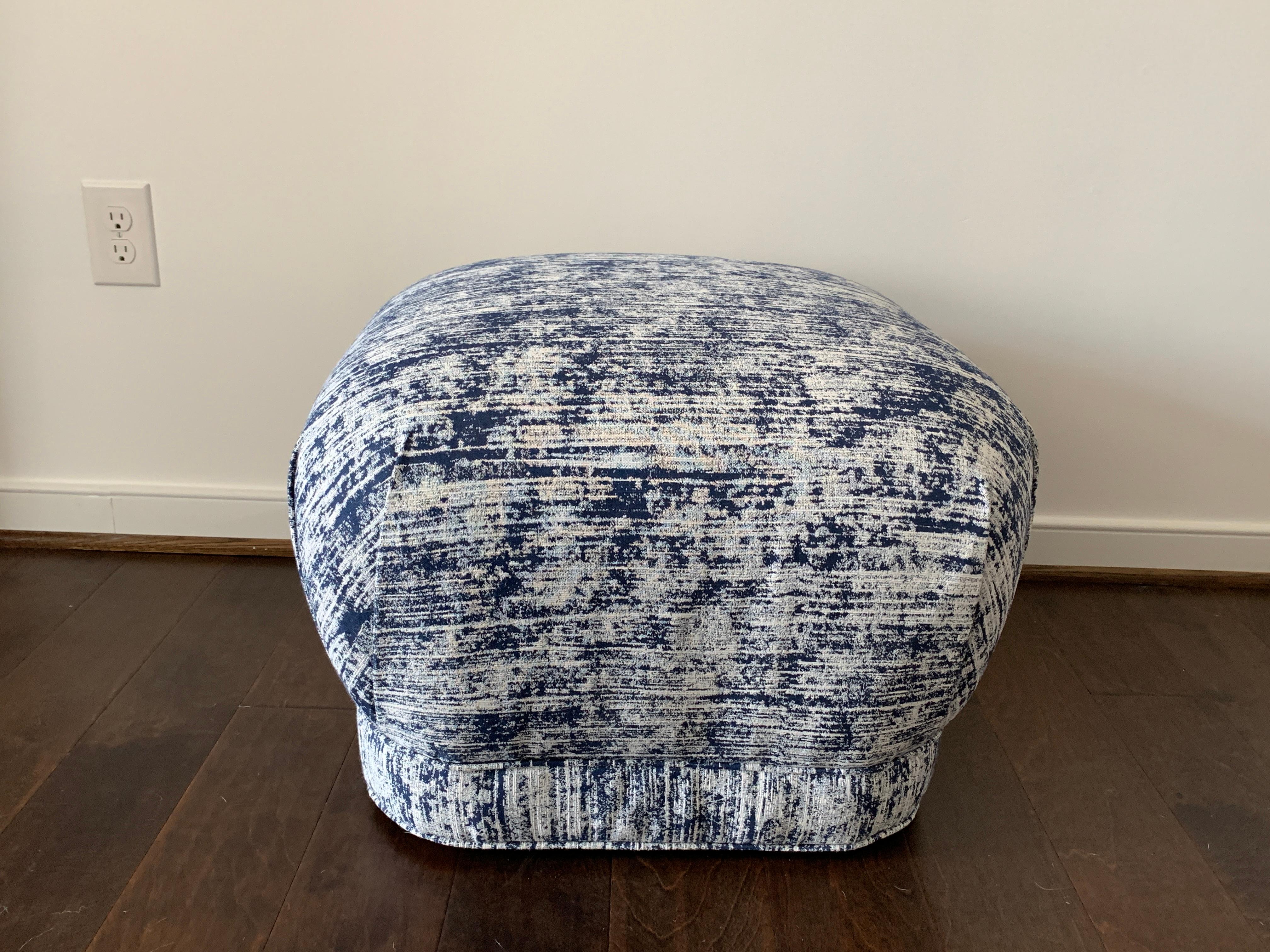 Listed is a fabulous, 1970s Karl Springer style soufflé pouf ottoman. The piece has been professionally upholstered in Scalamandré's 'Amalfi Weave' in the 'Indigo' colorway, from their 'Isola Indoor or Outdoor' collection. Self-welt and banding