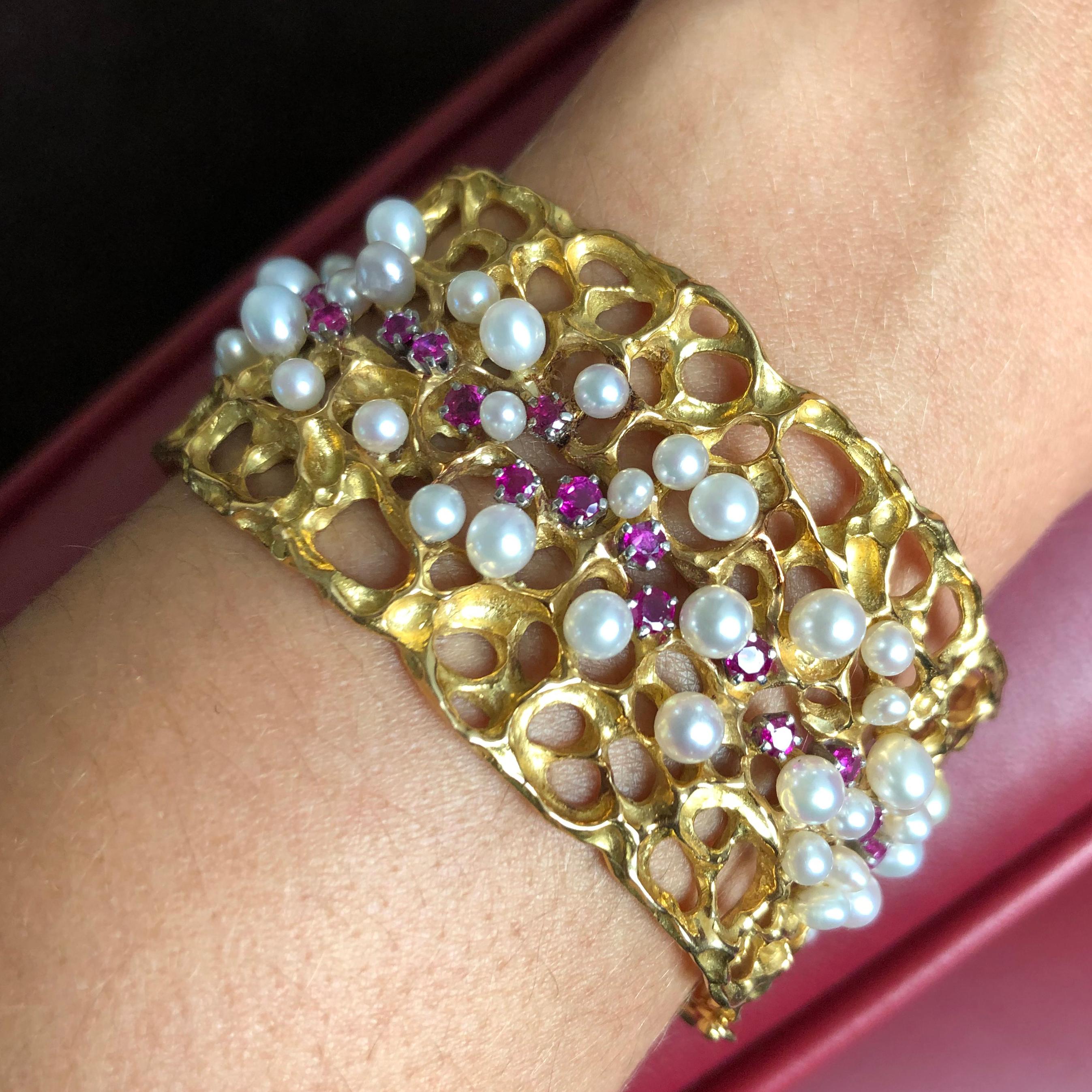 A pearl, ruby, sapphire and 18 karat gold bangle, by Karl Stittgen, 1970s, Canada. The bracelet is signed Stittgen 18k. It's inner circumference measures 6 3/8