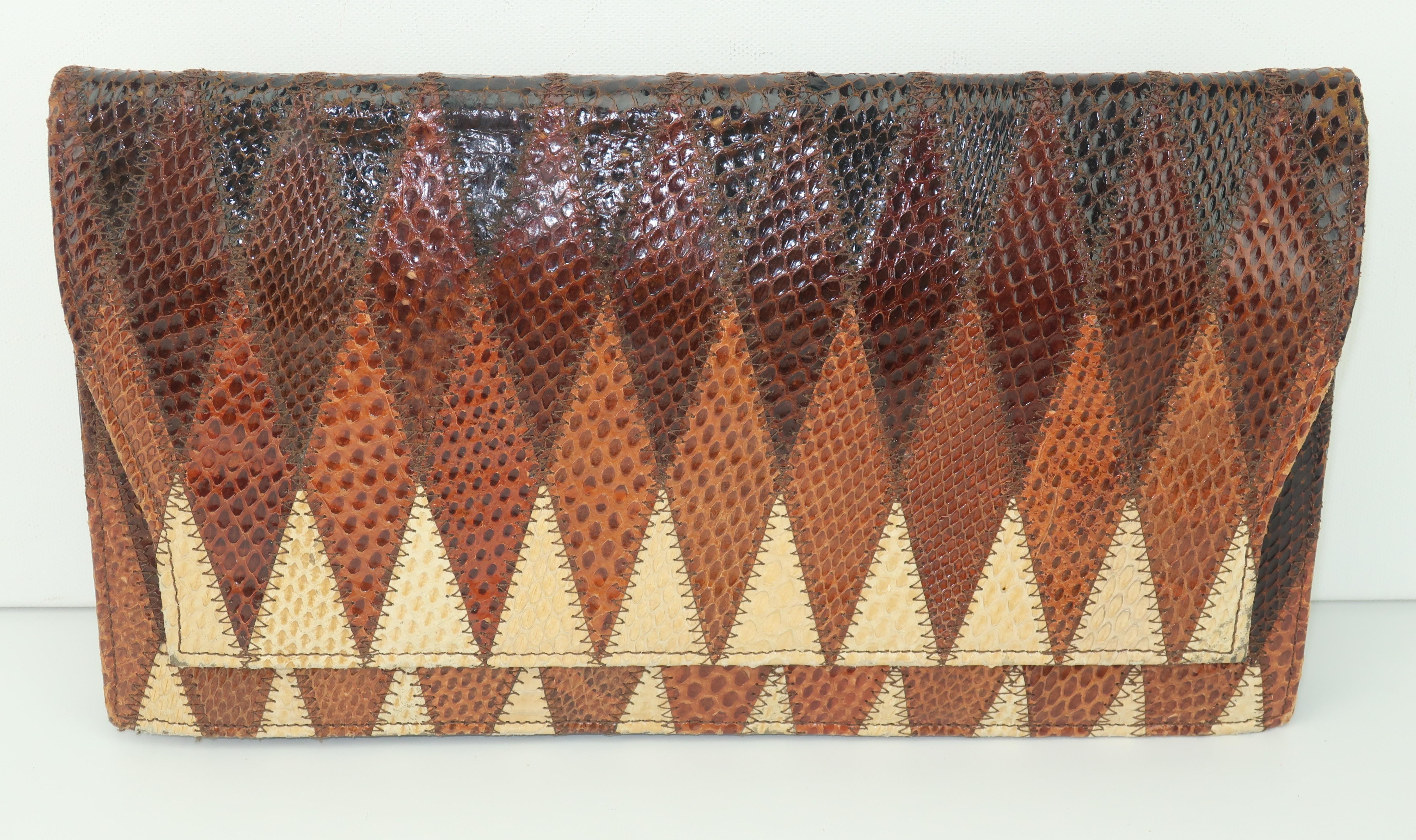 Patchwork perfection!  A 1970's Kaufmann of London patchwork snakeskin clutch handbag with a zigzag effect in shades of dark brown, chocolate and beige.  The envelope silhouette snaps open to reveal a faille fabric interior with an open pocket and