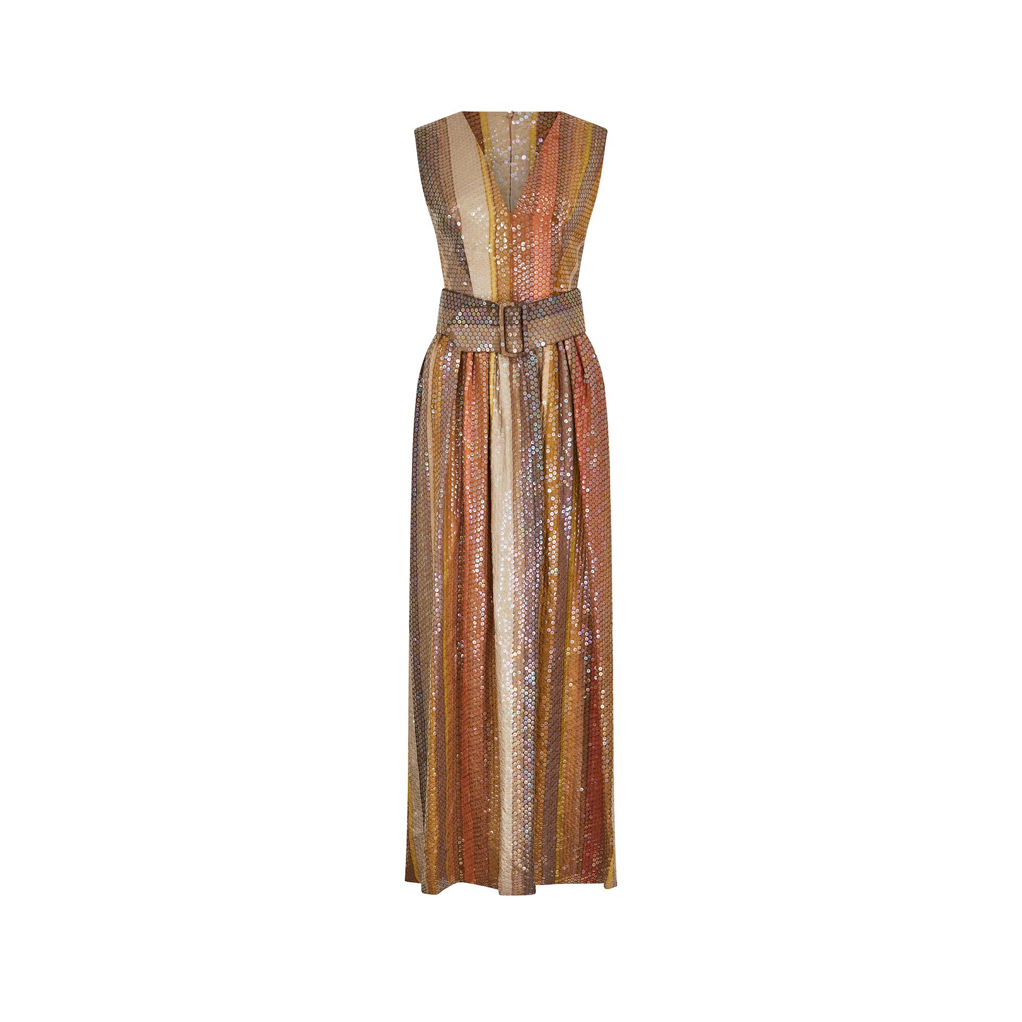 This late 1960s to early 1970s Kaye Walton sequin belted maxi dress exudes glamour and sophistication. The dress features vertical bands of sequins in a tonal range, including copper, golden sand, yellow ochre, taupe and brown.  Designed to flatter