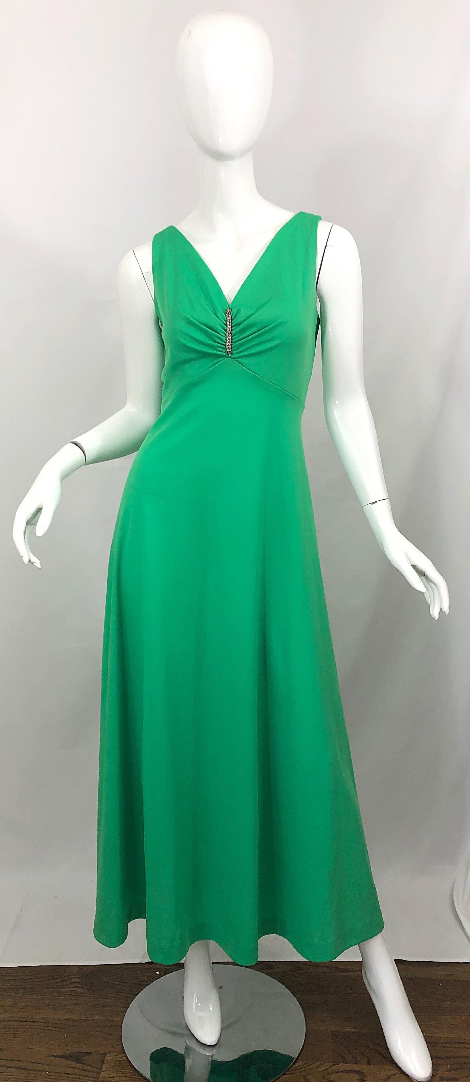 Beautiful 1970s kelly green rhinestone encrusted jersey maxi dress! Features sparkling rhinestones down the center tailored bodice. Forgiving and flattering full skirt. Hidden metal zipper up the back with hook-and-eye closure. Can easily work for