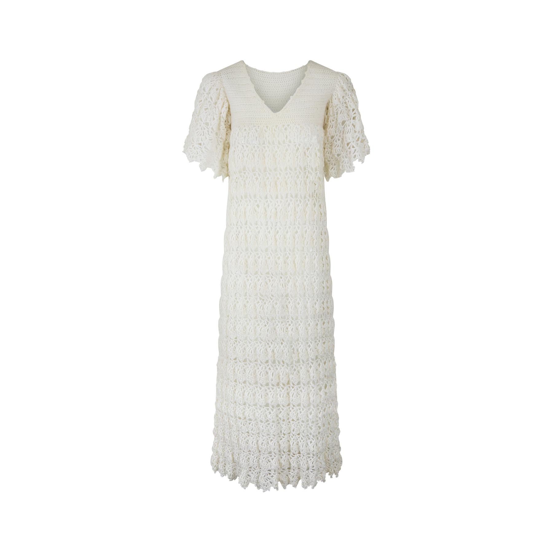 This 1970s knitted wool maxi dress has clearly been made with love and attention by a very good home knitter. It has a tighter knitted empire line bodice and a looser patterned ankle length skirt with horizontal rows of a geometric diamond-shaped