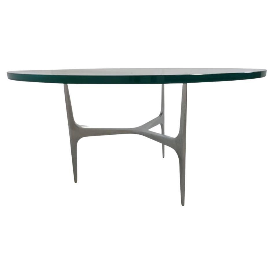 Here is a classic and unique Mid-Century Modern piece designed by the talented Knut Hesterberg for Ronald Schmitt. This amazing round tripod coffee table is made of aluminum and features a circular thick clear glass top. This is a timeless design.