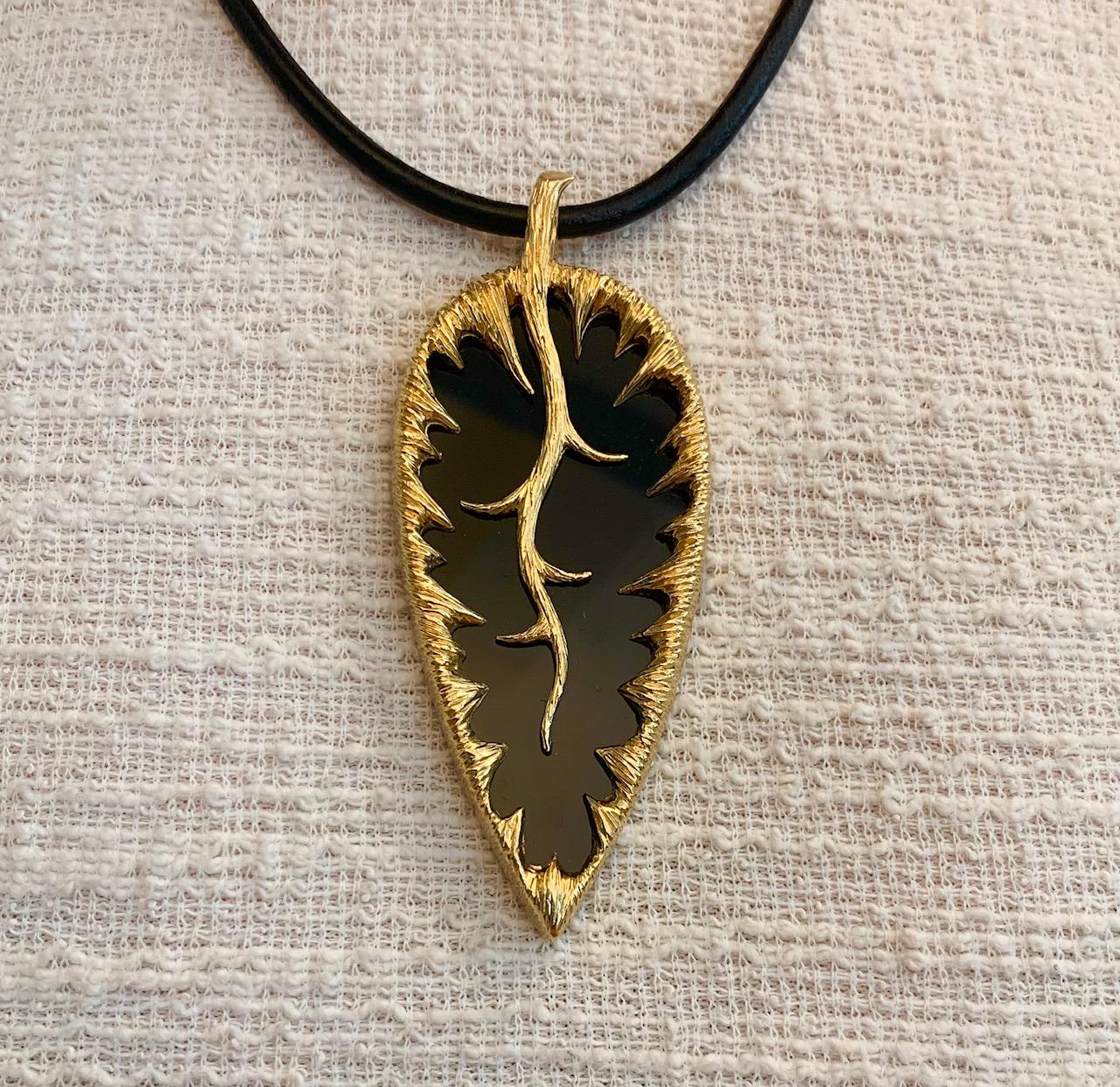 A large naturalist onyx and 18 karat textured gold leaf pendant, by the fashionable and fine jewelers, Kutchinsky, United Kingdom, 1973. 

The pendant is signed Kutchinsky. It is stamped with London hallmarks dated with letter 