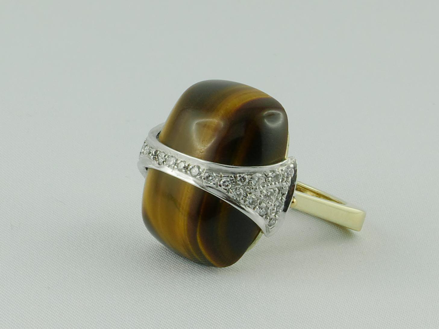This ring is 18 karat yellow and white gold with tiger eye and is set with about 1.25 carat  horizontal strip of Diamonds running through the center. The bold and geometric design make it chic, fashionable and extremely wearable.  Signed La Triomphe