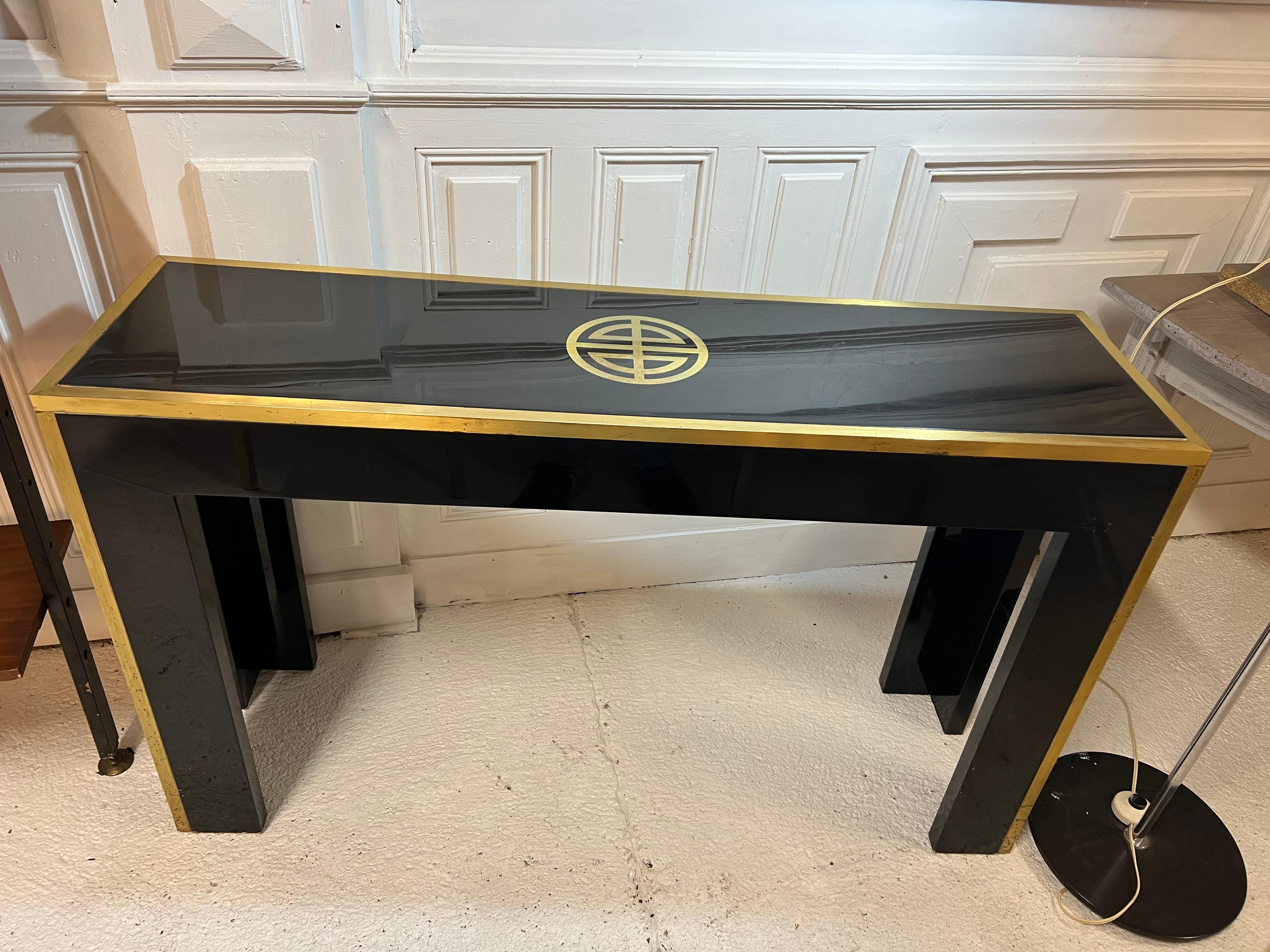 black lacquered and brass console by Guy Lefevre distributed by Jansen
its tray is monogrammed in a very 70's style

