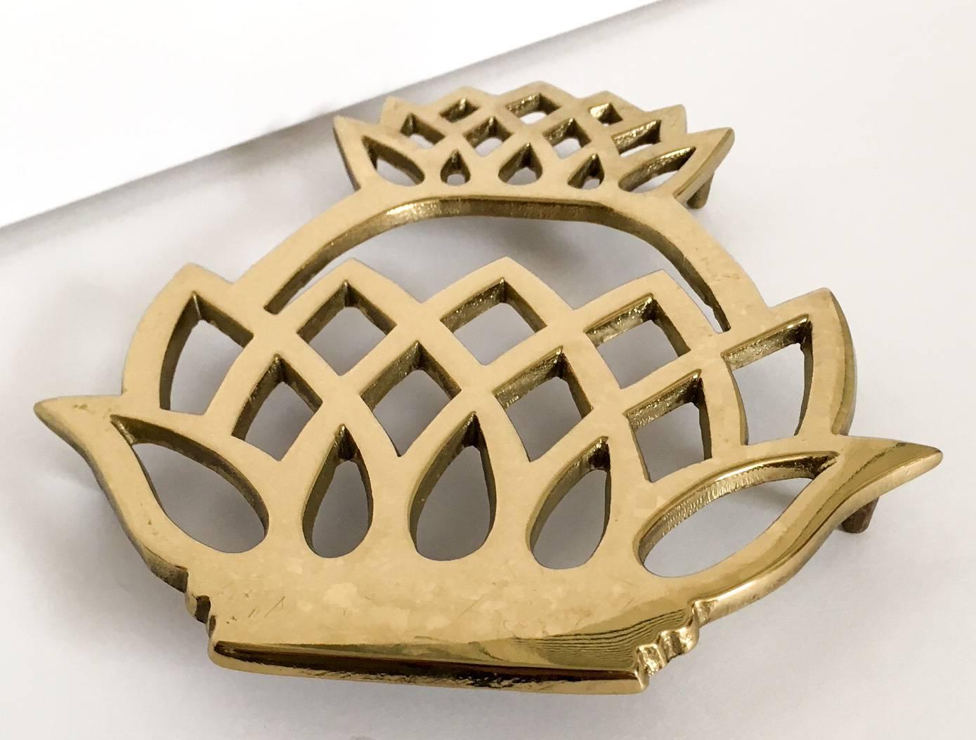 Handsome solid brass trivet in the form of a pineapple by the esteemed Virginia Metalcrafters (1953-2013). Made for the Historic Newport Reproduction collection. Some light scratches from use.