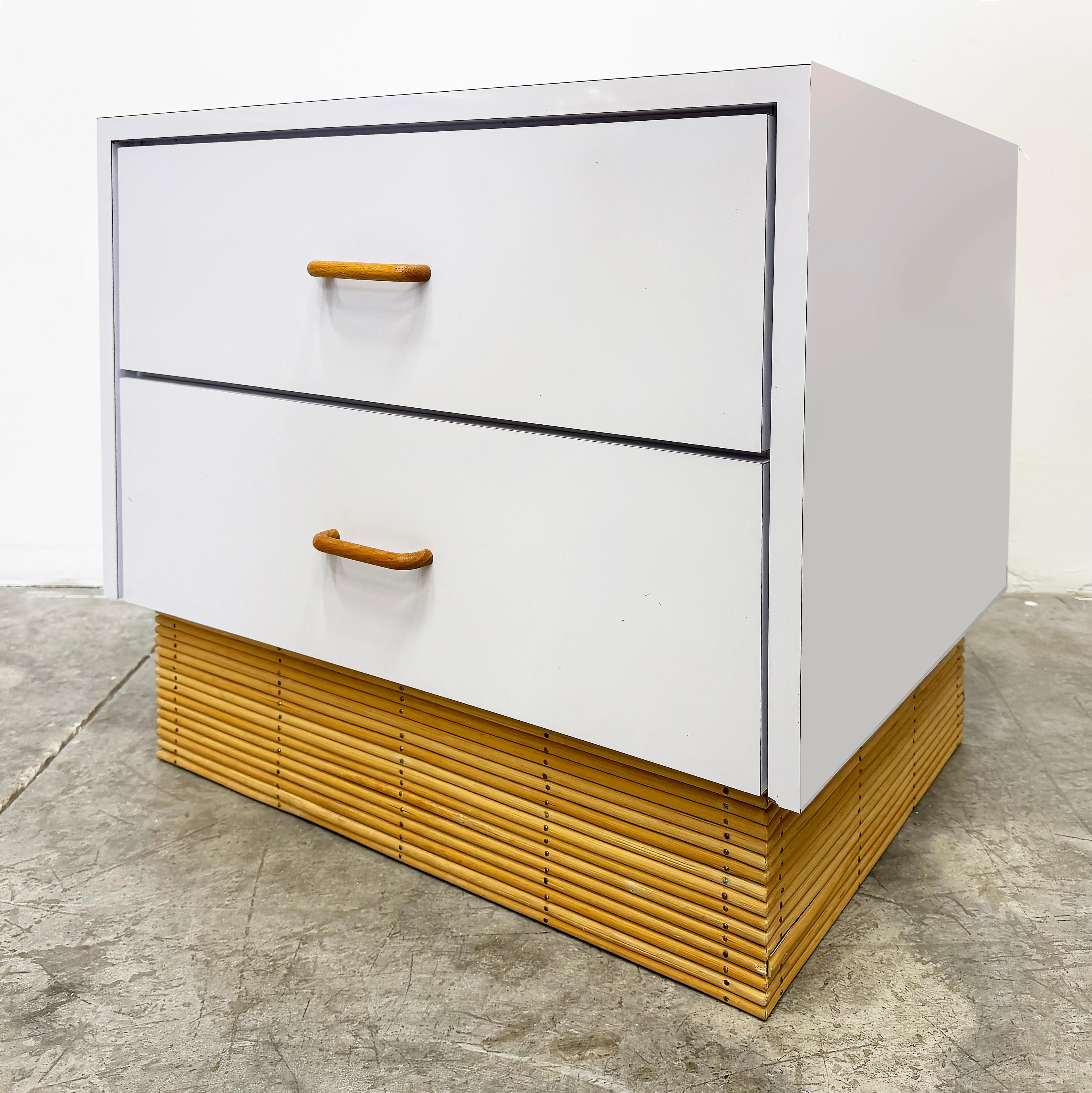 Comodino a 2 cassetti in laminato degli anni '70 con base a canne, maniglie in Wood

In vendita c'è un raro comodino a 2 cassetti rivestito in laminato bianco e rifinito con file di canne alla base. I cassetti sono puliti all'interno e rivestiti in