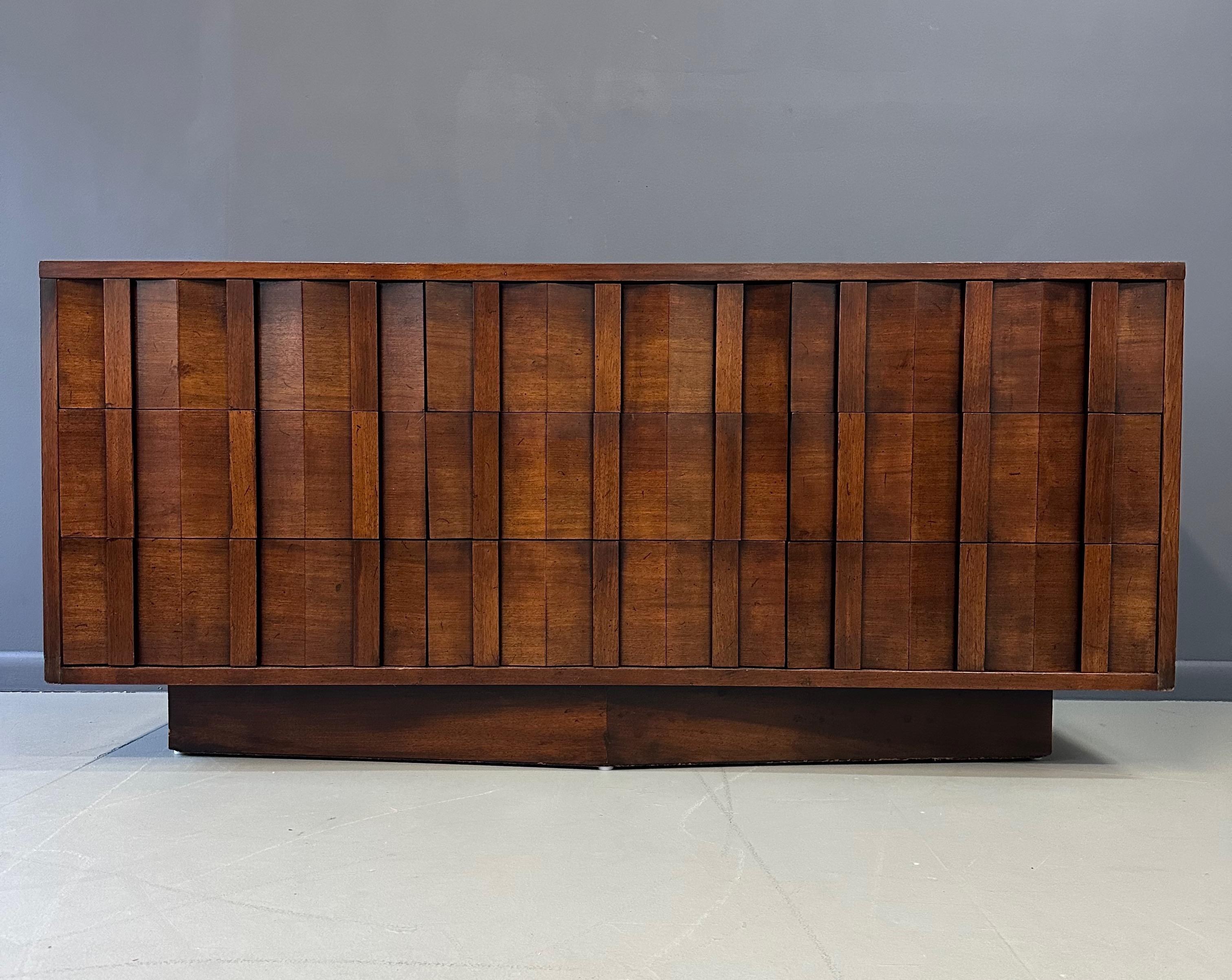 Esta cómoda de nueve cajones Lane Brutalist de los años 70 es un ejemplo impresionante del diseño de mediados de siglo. Con sus nueve amplios cajones, esta cómoda ofrece mucho espacio de almacenamiento y añade un toque único a cualquier habitación.