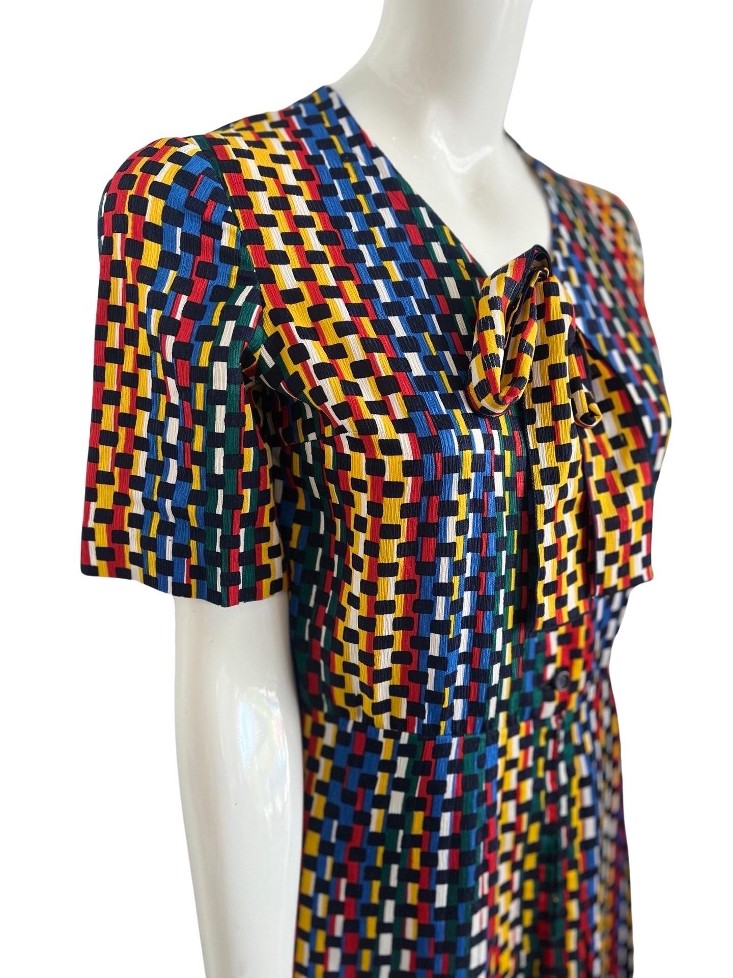 1970s Lanvin secretary dress in a bright mix of  primary colors in a sort of abstract layered brick print.  The fabric is polyester, as was popular by Lanvin in the day, however it feels close to a crepe silk and falls nicely.  The dress has a half