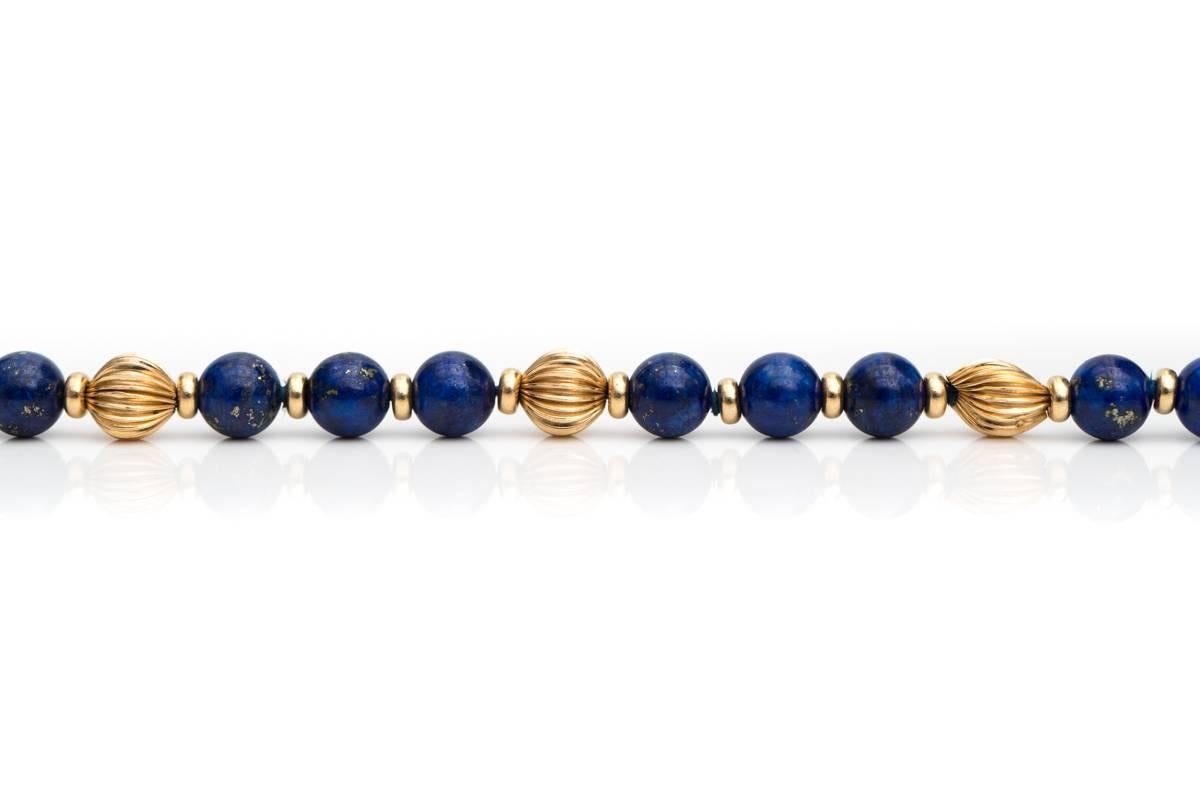 Lapis Lazuli and 14 Karat Yellow Gold Bead Bracelet

Features 18 Lapis Lazuli beads and 5 Yellow Gold Beads. The Lapis beads are round, smooth and deep blue. The Gold beads are round with a vertical, linear texture. The Lapis beads are arranged in