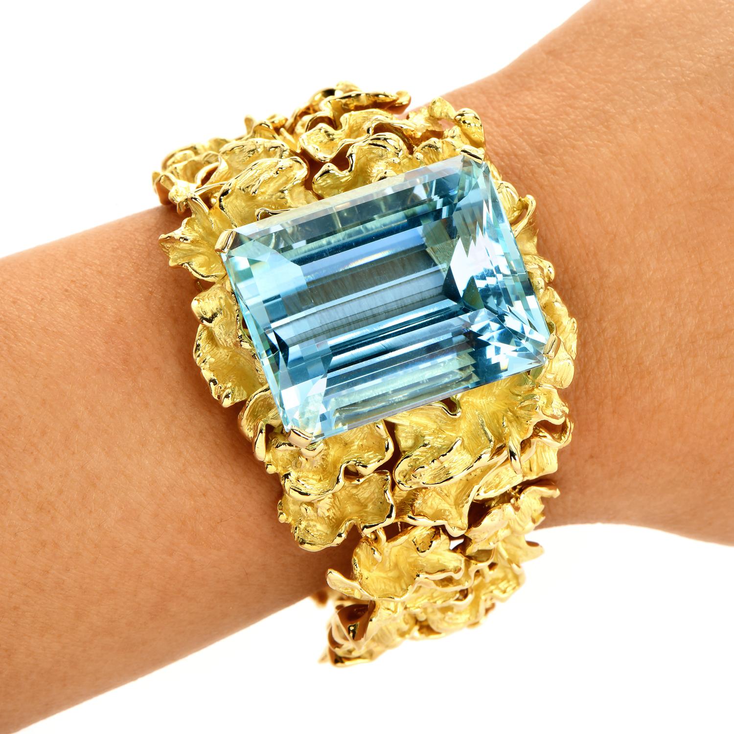 A show Stopper! for a bright and unique wearer. 

Adorn your arm with this statement piece, an aquamarine wide nugget gold bracelet.  

Crafted in solid 18K yellow gold, the intricate nugget pattern in the links creates a graduated style for